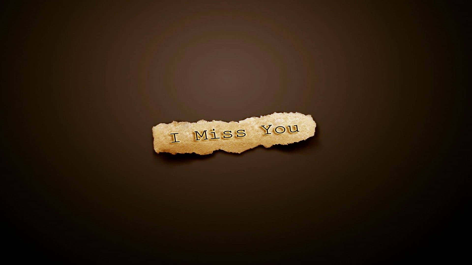 我想你 桌布 壁紙 — 一張撕破的紙片，上面有金色字體寫著「I Miss You」，漂浮在深棕色漸變背景上。