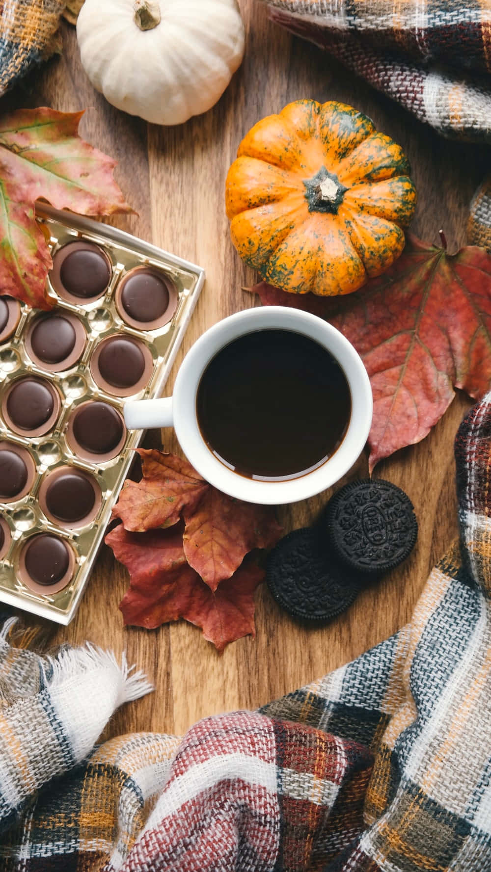 Autumn Food 桌布 壁紙 — 一張木桌上擺放著咖啡、巧克力餅乾、南瓜和樹葉的舒適秋日靜物照。