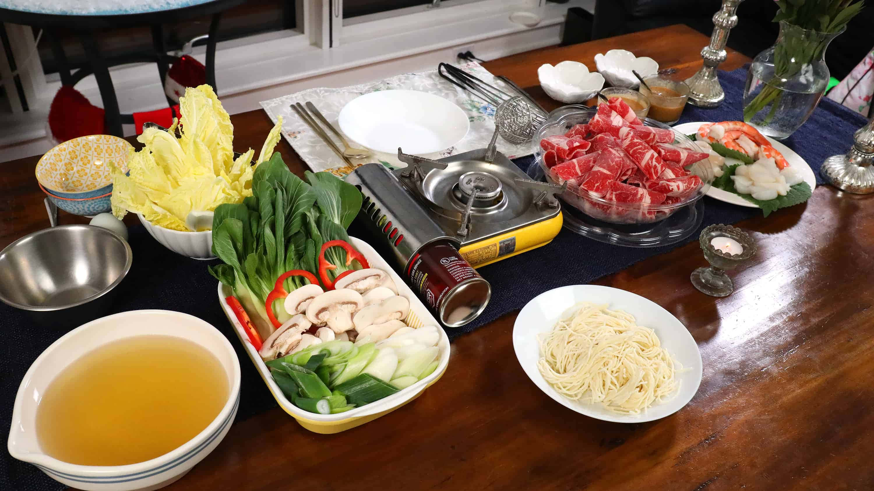 meat 桌布 壁紙 — 一張木桌上擺滿了火鍋食材，包括生肉、蝦、蔬菜和湯底，準備烹煮。