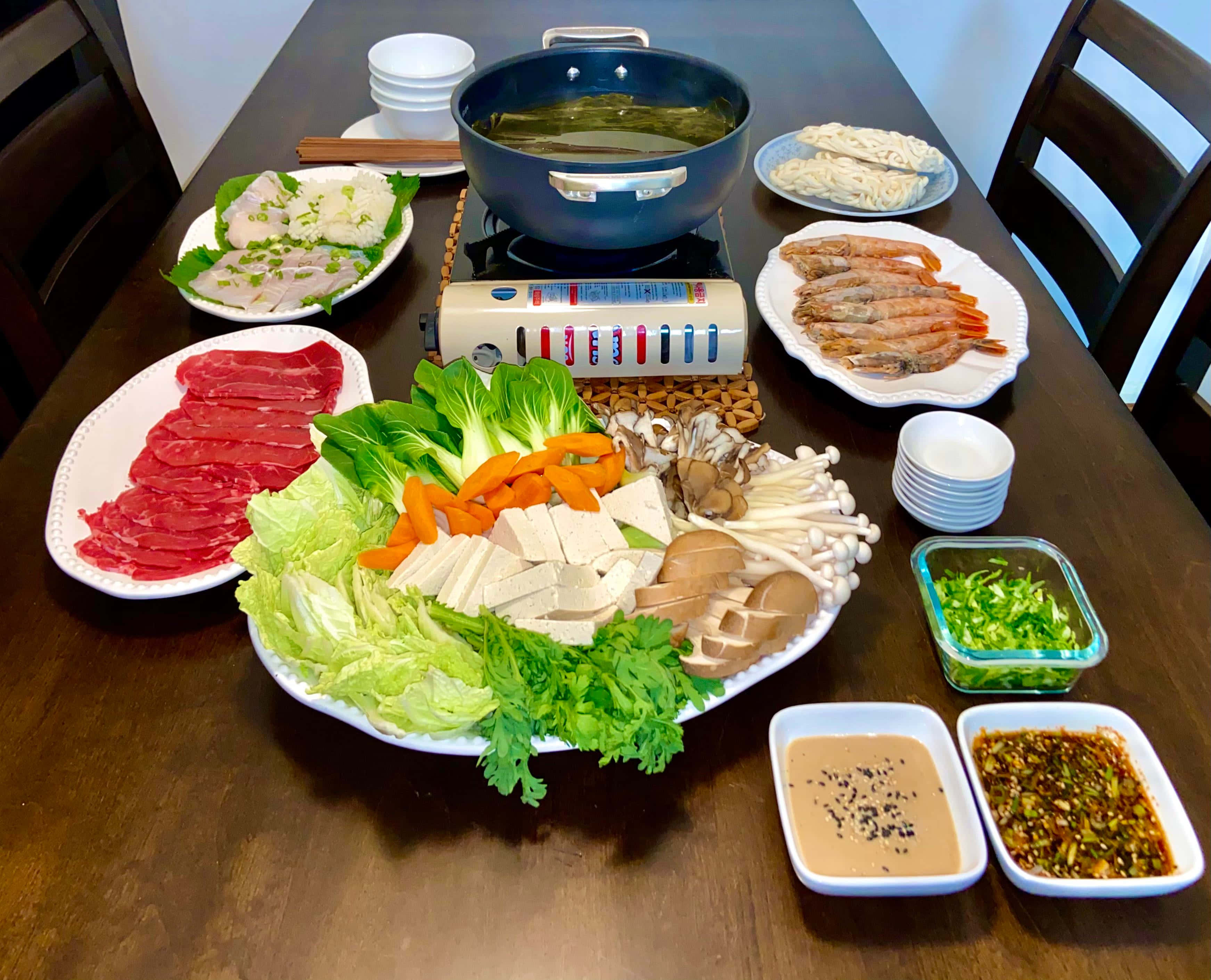meat 桌布 壁紙 — 一張木桌上擺滿了色彩繽紛的火鍋食材，包括切片牛肉、蝦、蘑菇和新鮮蔬菜。