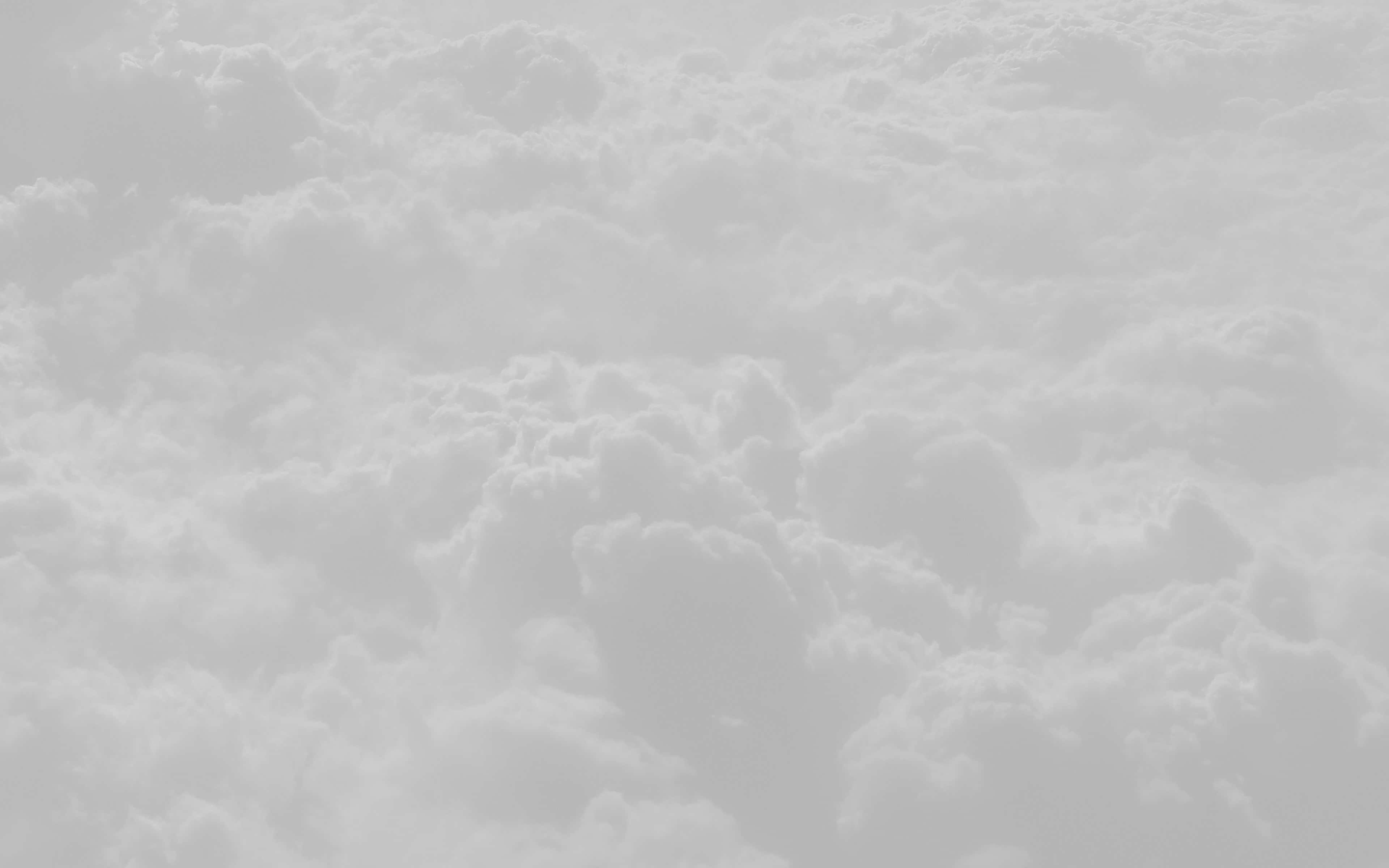 White Clouds 桌布 壁紙 — 一張柔和的黑白航拍圖，蓬鬆的雲朵在天空中無盡延伸。
