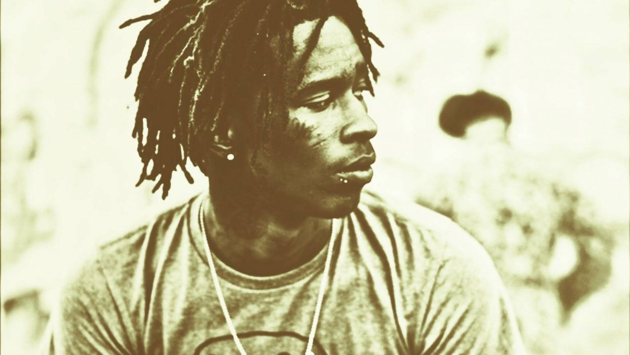 Thug 桌布 壁紙 — 一張棕褐色調的肖像，一名留著辮子的男子在柔和模糊的背景中若有所思地凝視一側。