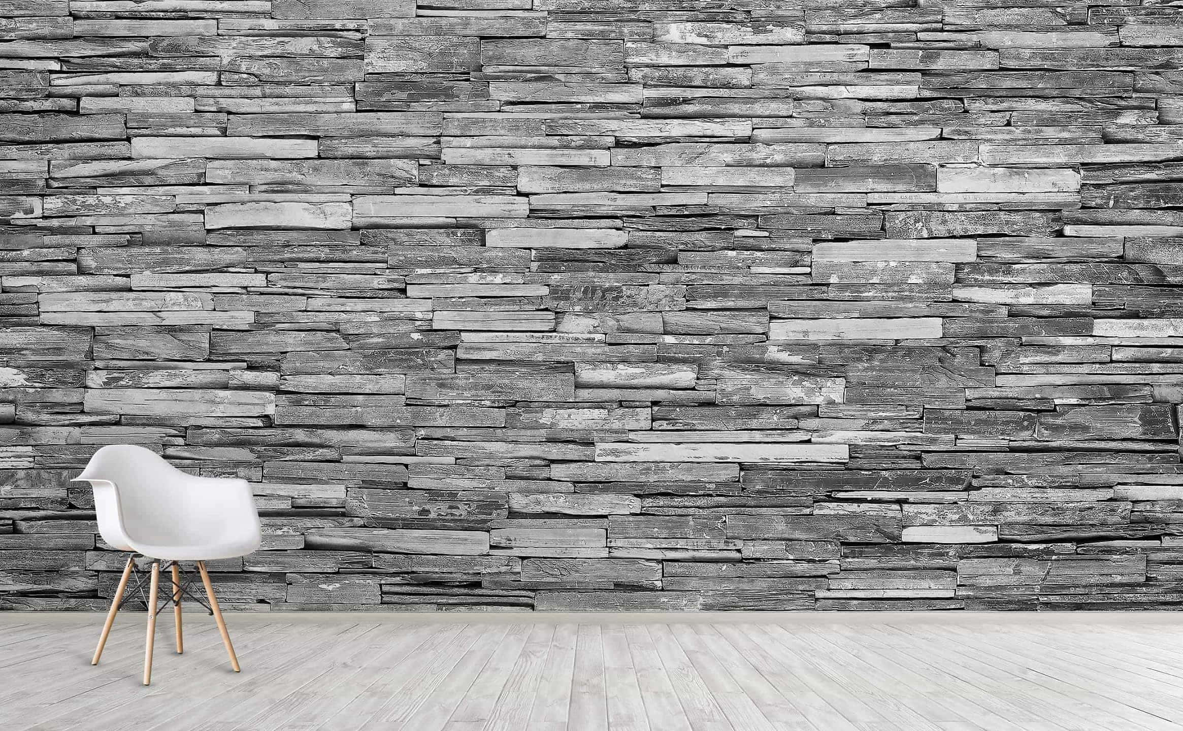 Concrete Texture 桌布 壁紙 — 一張極簡白色木腳椅子獨自靠著質感灰色石牆，位於明亮的現代房間中。
