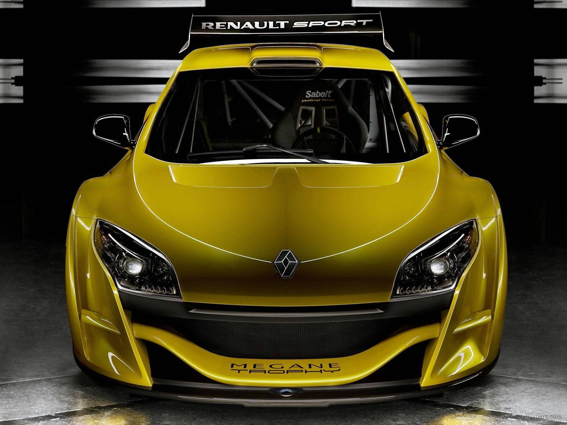 Renault 桌布 壁紙 — 一張正面拍攝的鮮黃色雷諾梅甘娜獎盃賽車，帶有黑色飾邊和賽車貼紙，在攝影棚燈光下。