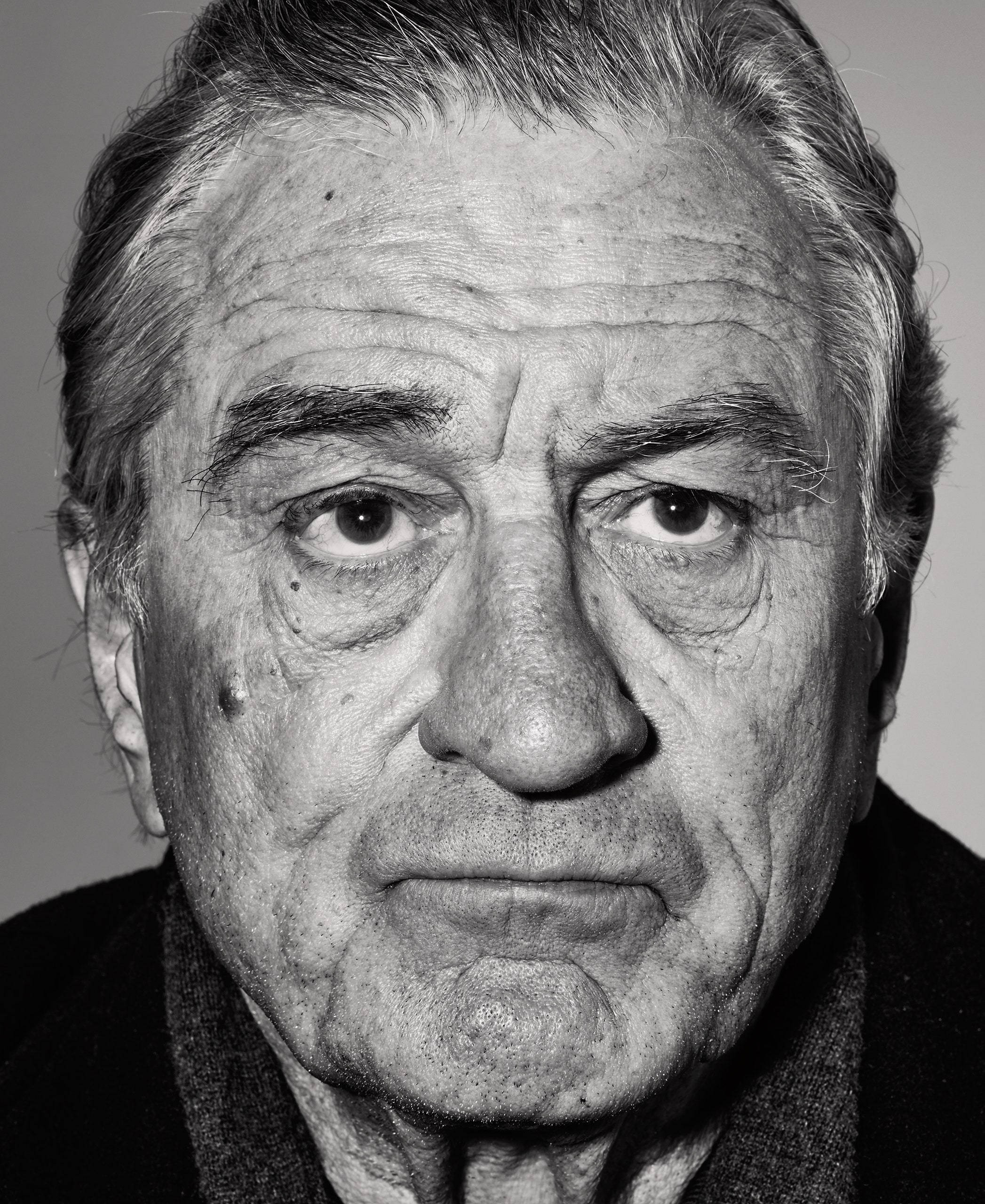 Robert De Niro 桌布 壁紙 — 一張清晰的黑白特寫肖像，捕捉一位滿臉皺紋、眼神銳利的長者直視鏡頭。