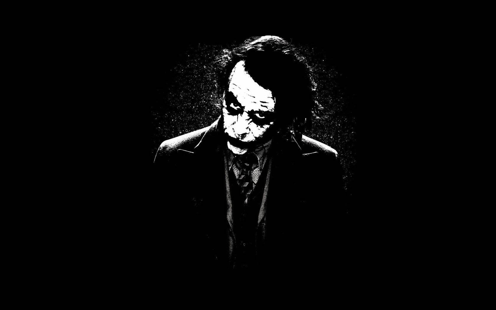 Heath Ledger Joker 桌布 壁紙 — 一張清晰的黑白肖像，小丑化妝模糊，頭髮凌亂，背景陰暗。