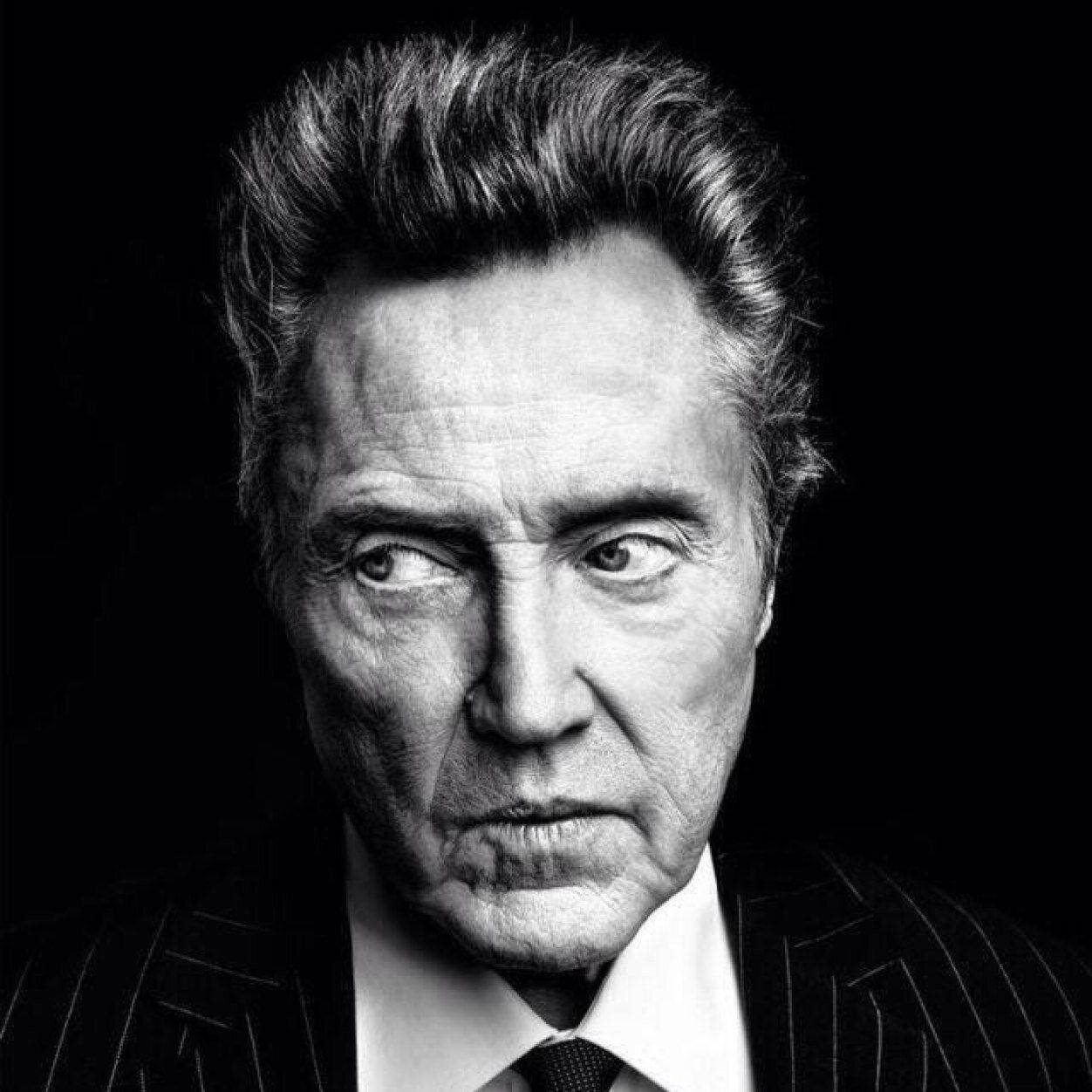 Celebrity 桌布 壁紙 — 一張清晰的黑白肖像，拍攝一位身穿細條紋西裝、眼神銳利、眉頭緊鎖的男子，背景為深色。