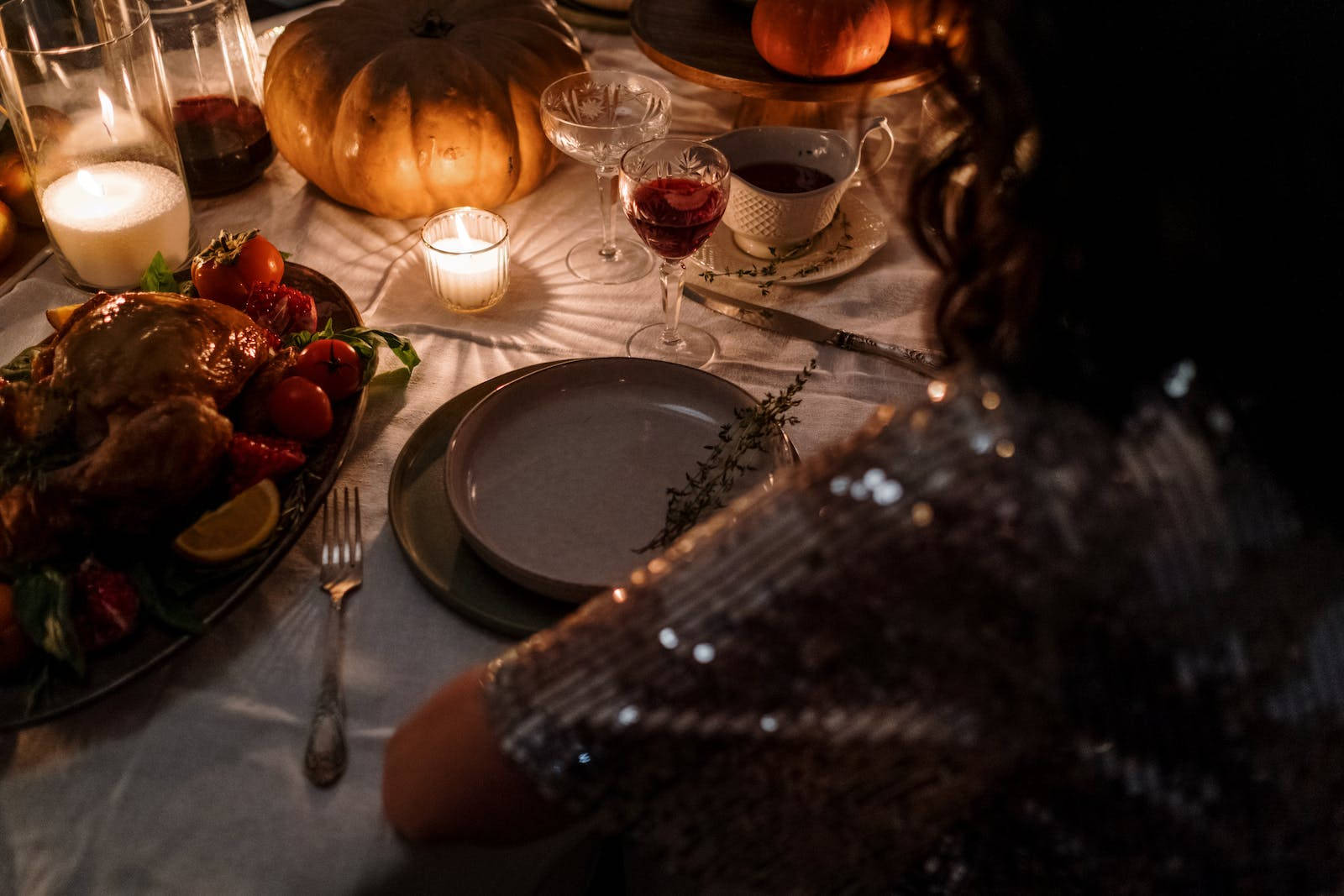 Thanksgiving Day 桌布 壁紙 — 一張溫暖燈光的秋季晚餐桌，擺放著烤火雞、蠟燭、南瓜和葡萄酒，在柔和燭光下。