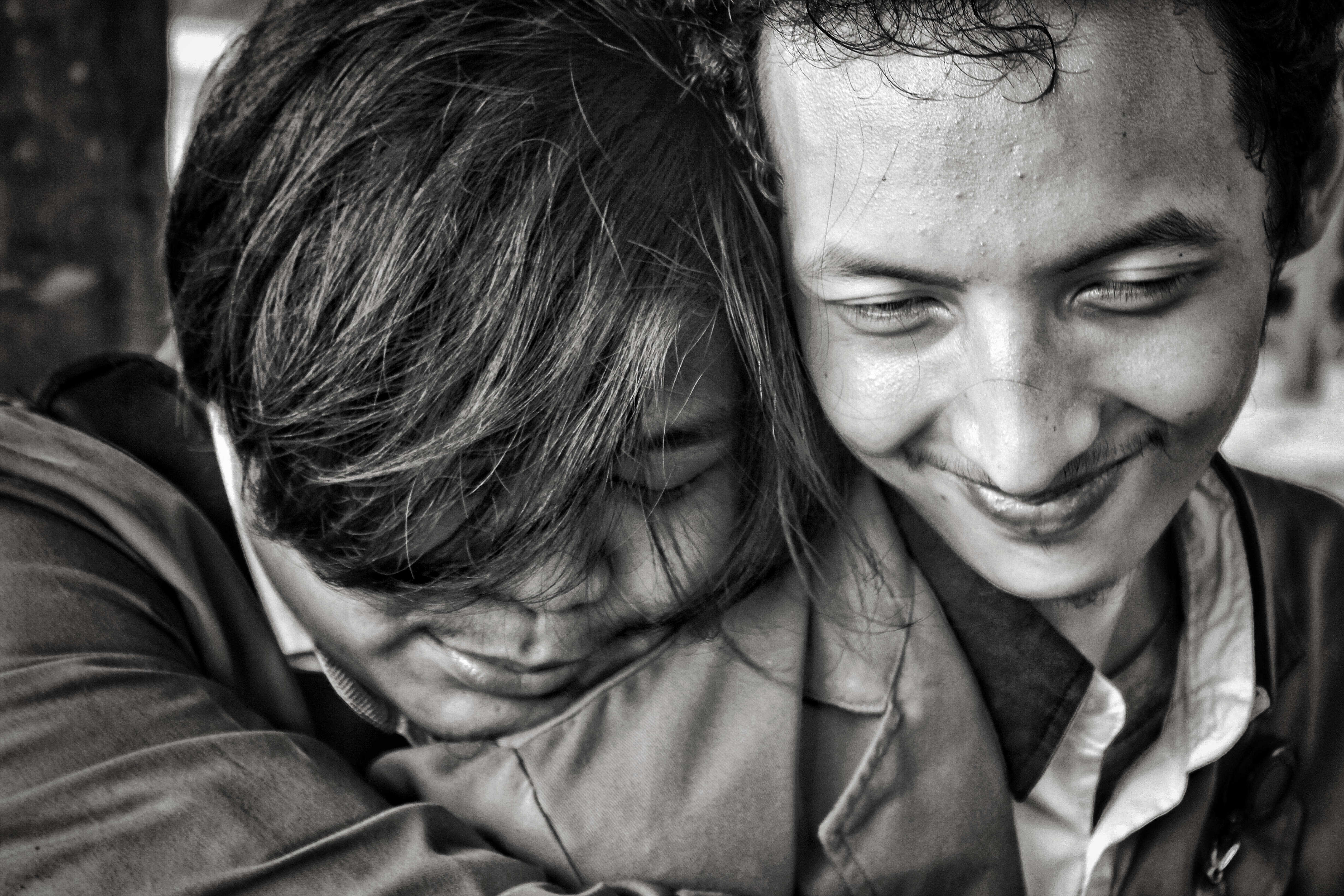Love And Friendship 桌布 壁紙 — 一張溫柔的黑白特寫，兩個人擁抱在一起，帶著柔和的笑容和閉上的眼睛，傳達出深厚的感情。