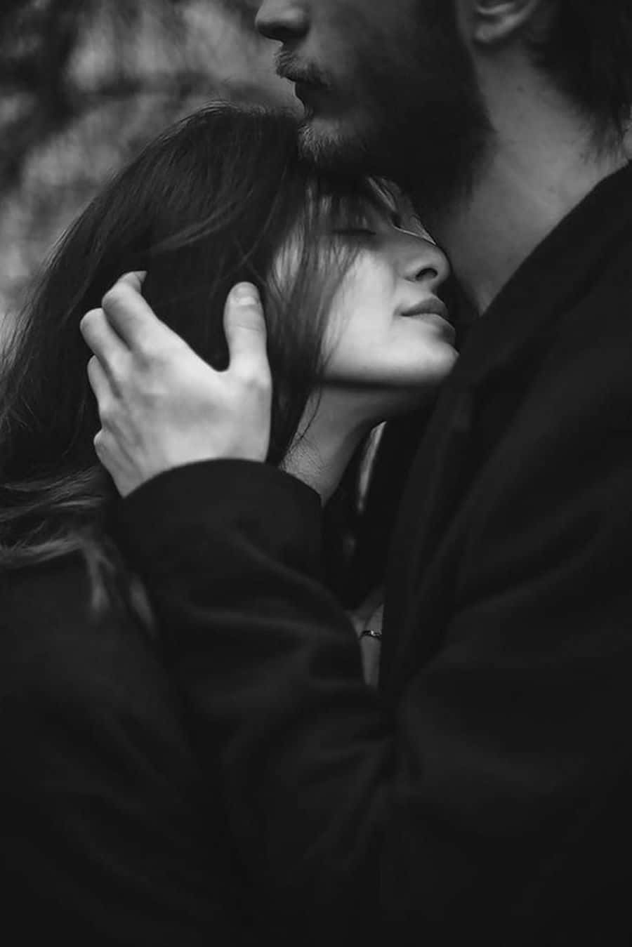 Black Couple 桌布 壁紙 — 一張溫柔的黑白特寫，男人輕輕地捧著女人的頭，而她閉著眼睛靠在他身上休息。