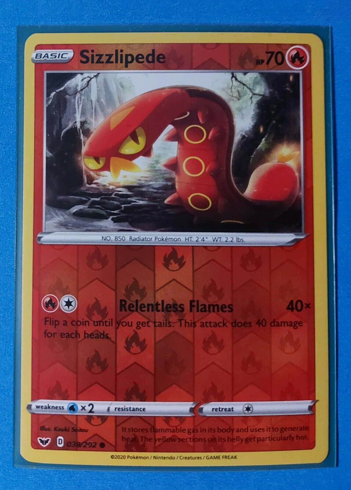 Pokemon Card 桌布 壁紙 — 一張火紅色的Sizzlipede寶可夢卡，帶有黃色眼睛和火焰圖案，以黑暗森林為背景。