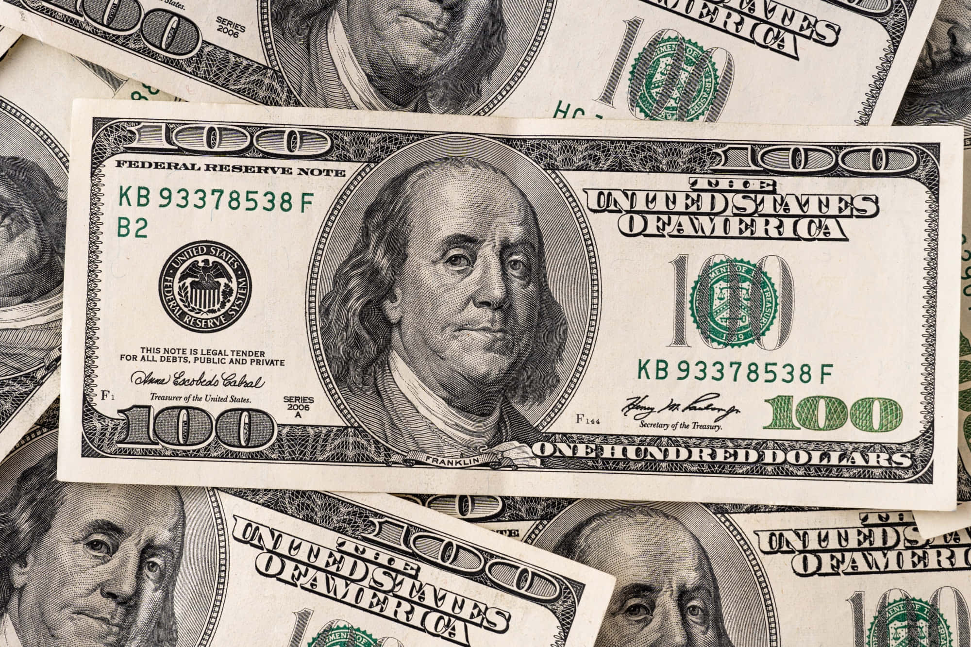 Money 桌布 壁紙 — 一張特寫，展示重疊的百元美鈔，上面有班傑明·富蘭克林的肖像和綠色墨水細節。