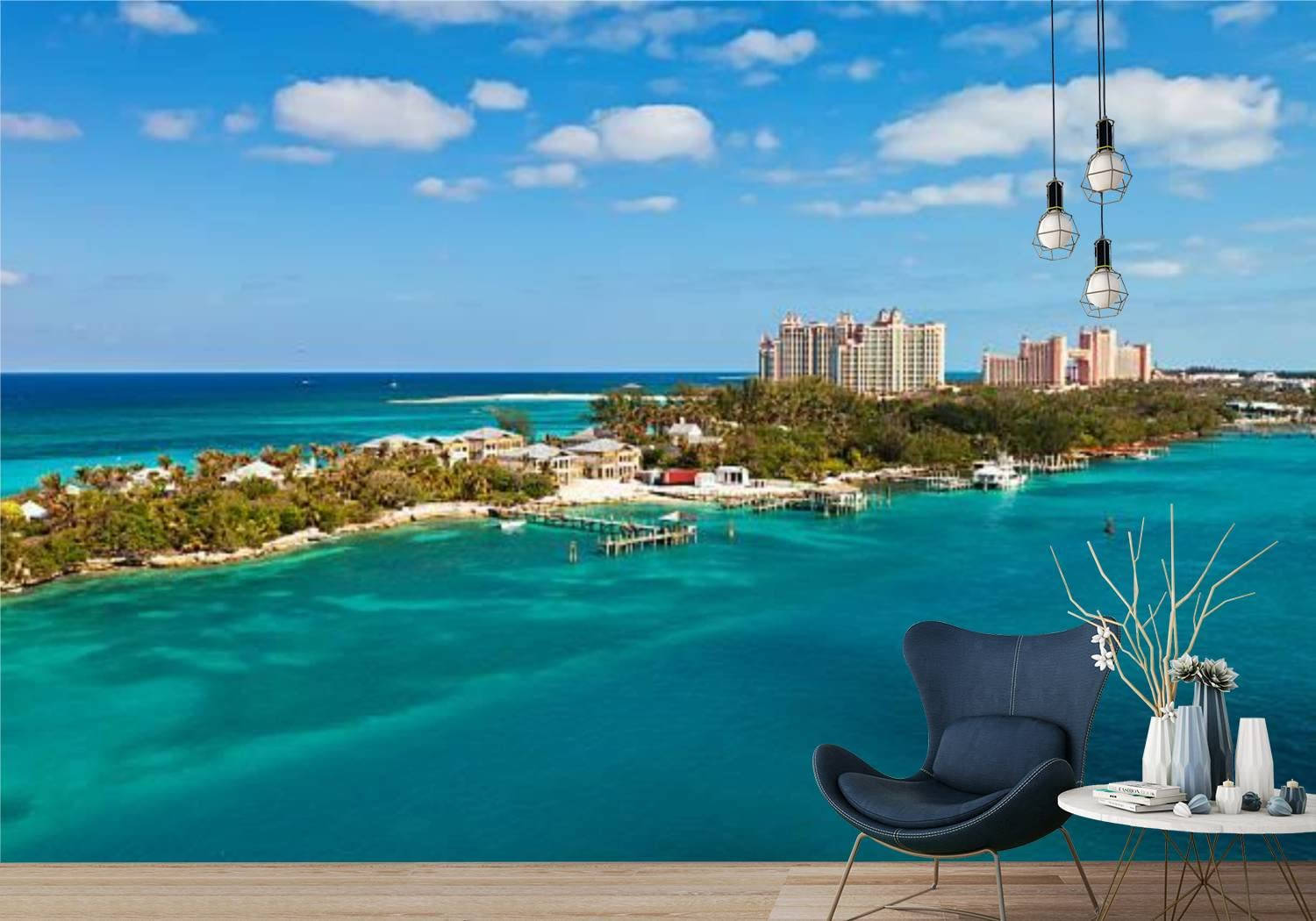 Nassau Bahamas 桌布 壁紙 — 一張現代休閒椅放在充滿活力的藍綠色海景前，有度假村建築和棕櫚樹，在明亮的藍天下。