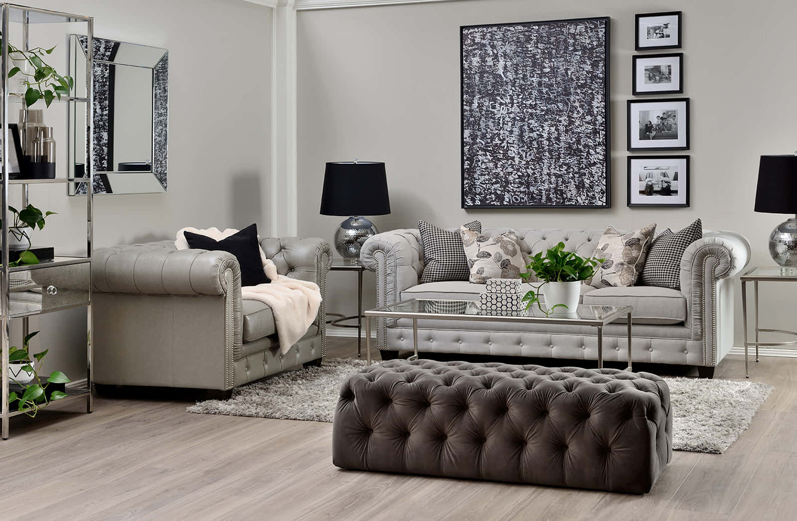 Living Room 桌布 壁紙 — 一張現代灰色簇絨沙發和扶手椅位於時尚的客廳中，配有抽象藝術、黑色燈具和綠色植物。