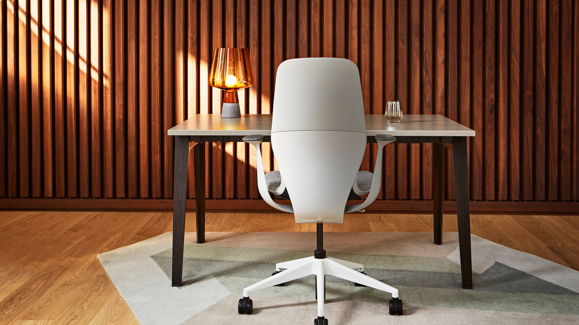 Office Space 桌布 壁紙 — 一張現代白色辦公椅放在一張時尚的書桌上，溫暖的陽光透過垂直的木條照射進來。