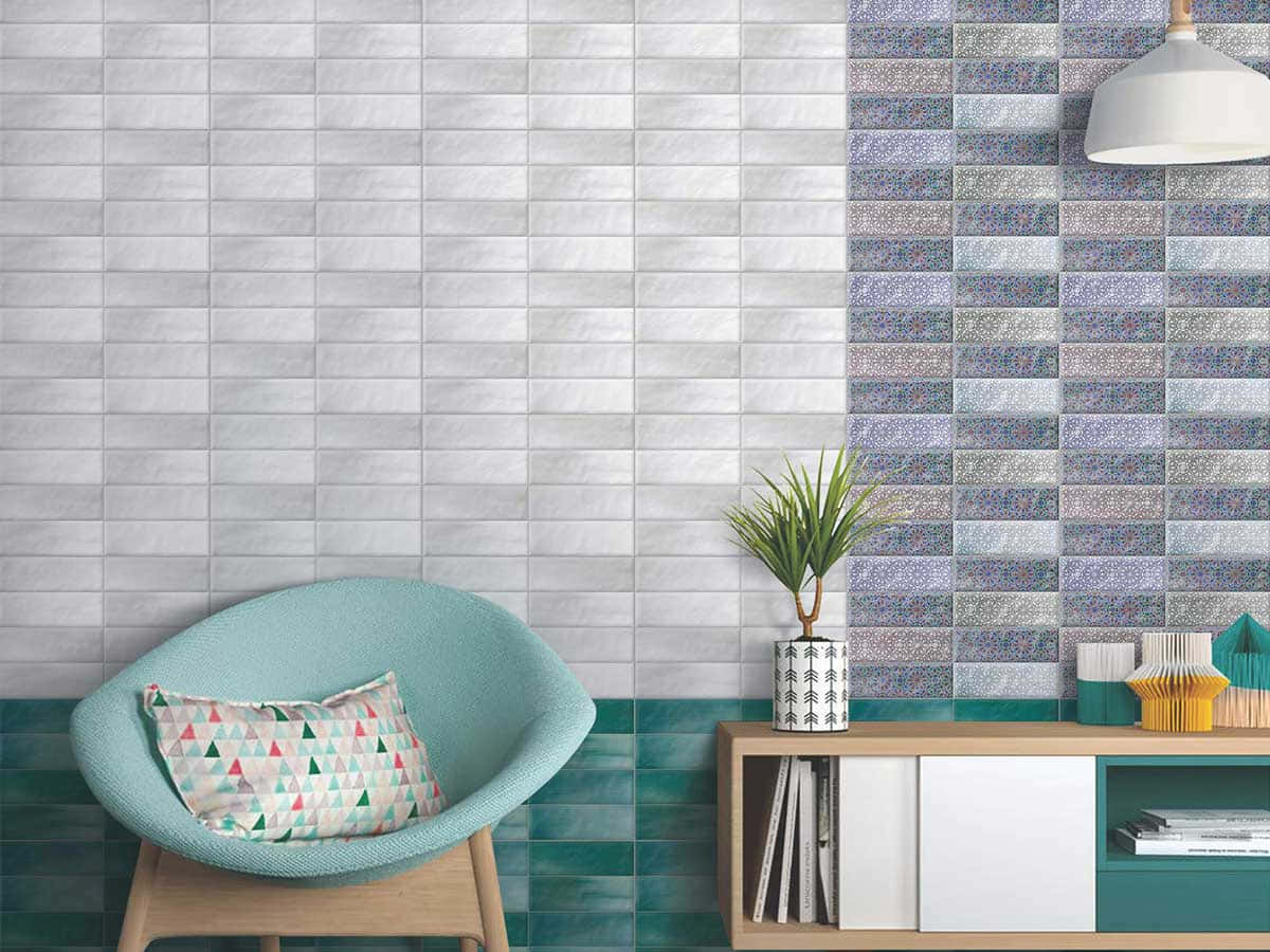 Tiles 桌布 壁紙 — 一張現代青綠色扶手椅配圖案靠墊，旁邊是木製控制台，背景是灰色和青綠色馬賽克圖案的瓷磚牆。