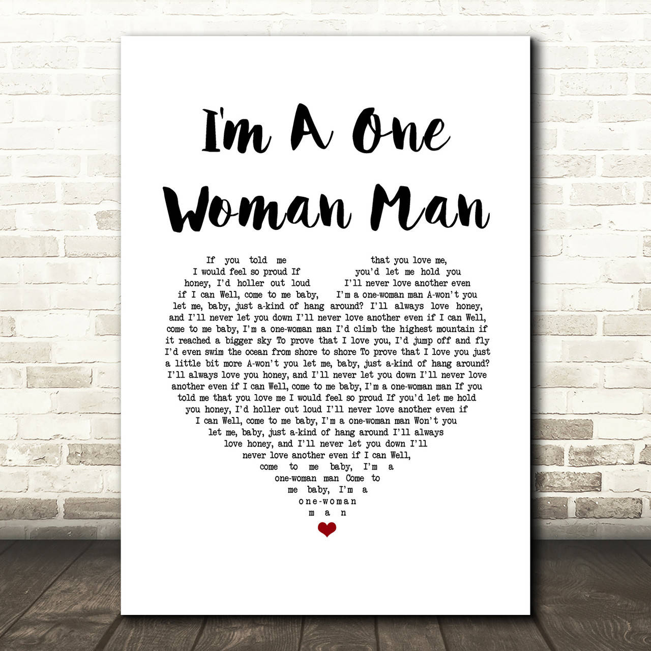 鄉村 桌布 壁紙 — 一張白色海報，上面有粗體黑色文字寫著「I'm A One Woman Man」和歌詞，安裝在淺色磚牆上，下方是木地板。