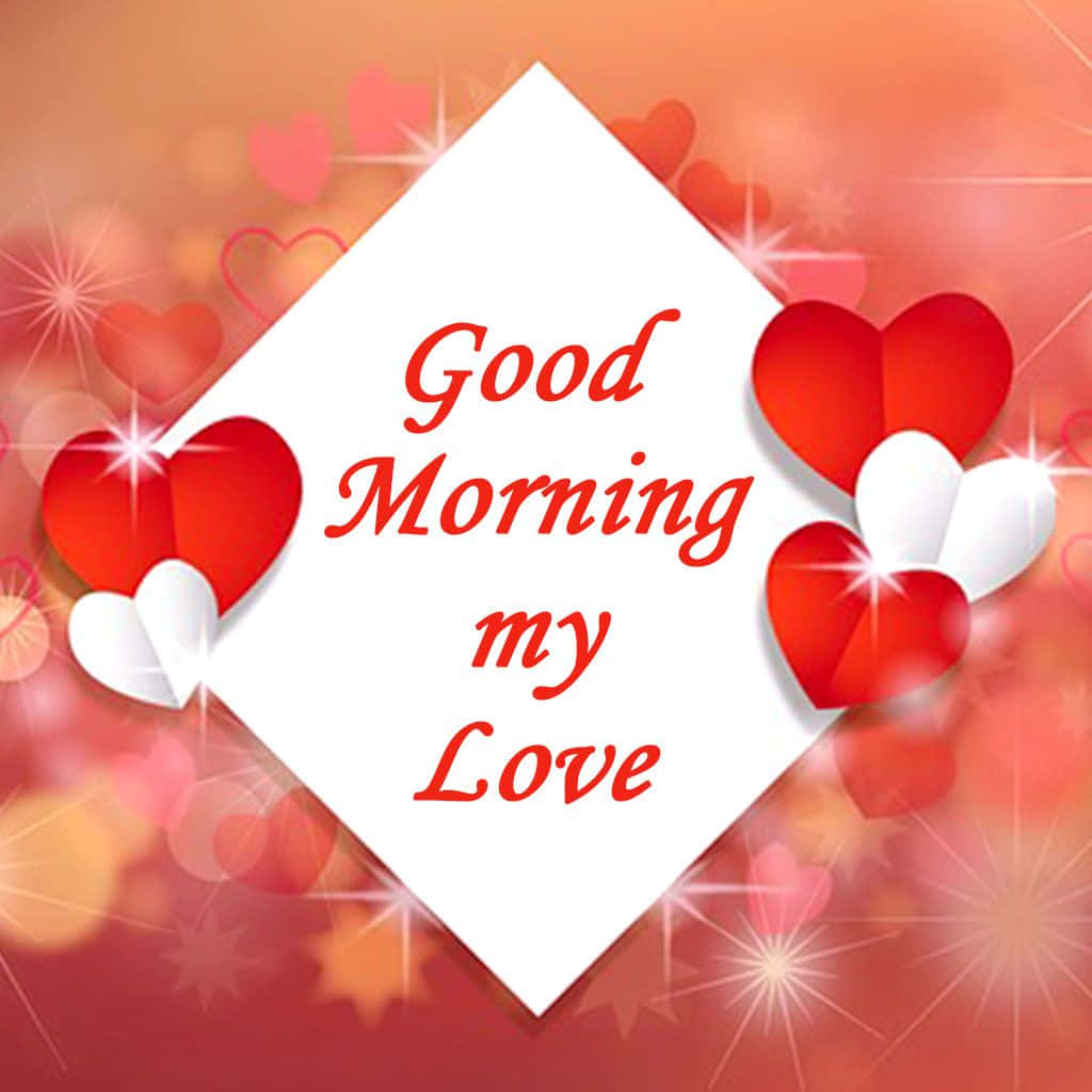  壁紙 — 一張白色鑽石形卡片，上面有紅色草書文字寫著「Good Morning my Love」，周圍環繞著發光的紅色和白色心形，背景為溫暖的漸變色。