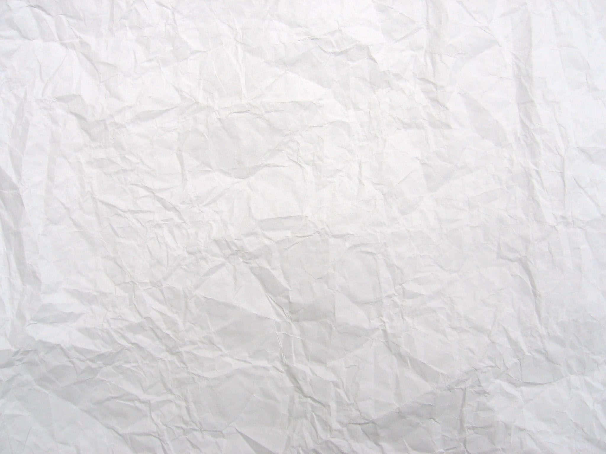 White Paper 桌布 壁紙 — 一張皺巴巴白紙的特寫，柔和陰影突顯其紋理摺痕和皺褶。