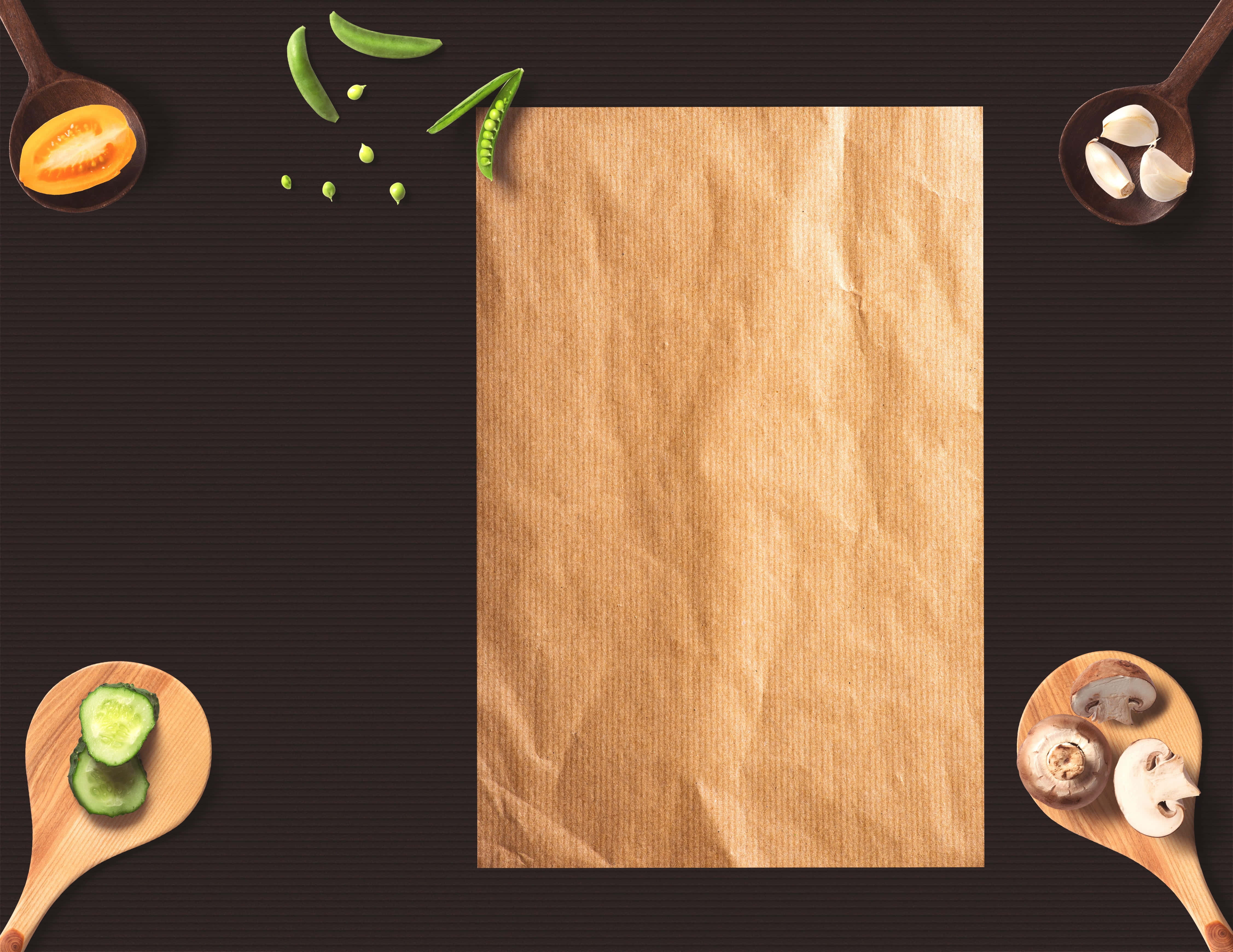 Brown Paper 桌布 壁紙 — 一張皺巴巴的棕色紙張置於深色表面中央，周圍是木勺上的新鮮蔬菜。