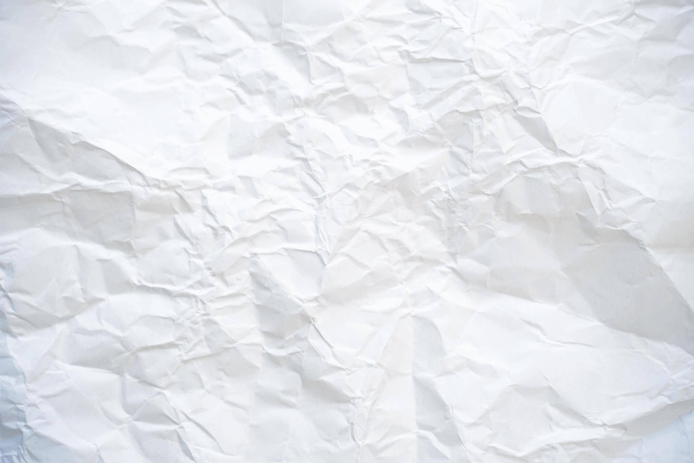 paper 桌布 壁紙 — 一張皺巴巴的白紙特寫，柔和陰影突顯其紋理摺痕和皺褶。