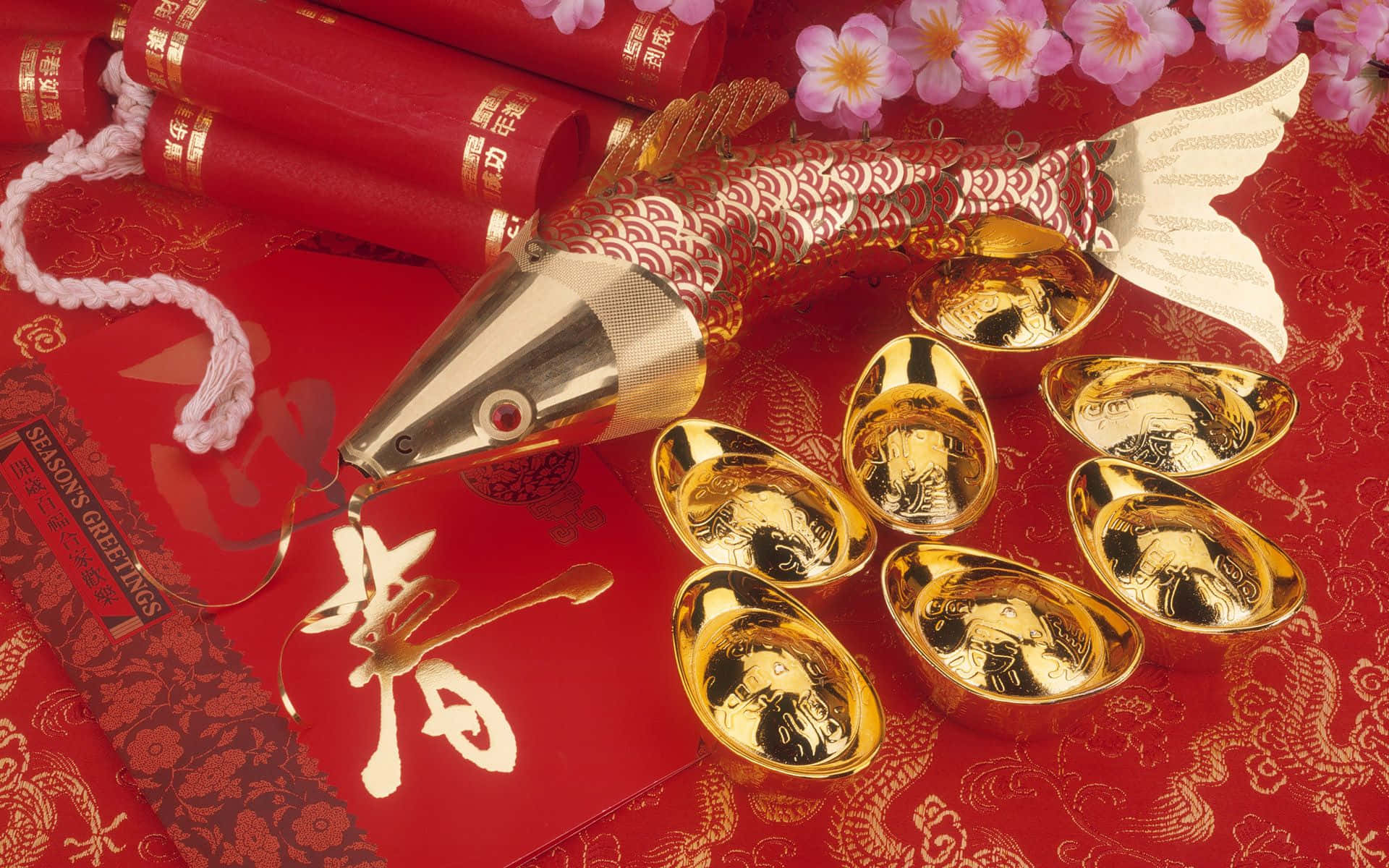 春節 桌布 壁紙 — 一張節慶紅色桌布，飾有金元寶、金屬魚飾和盛開的粉紅花朵，迎接農曆新年。