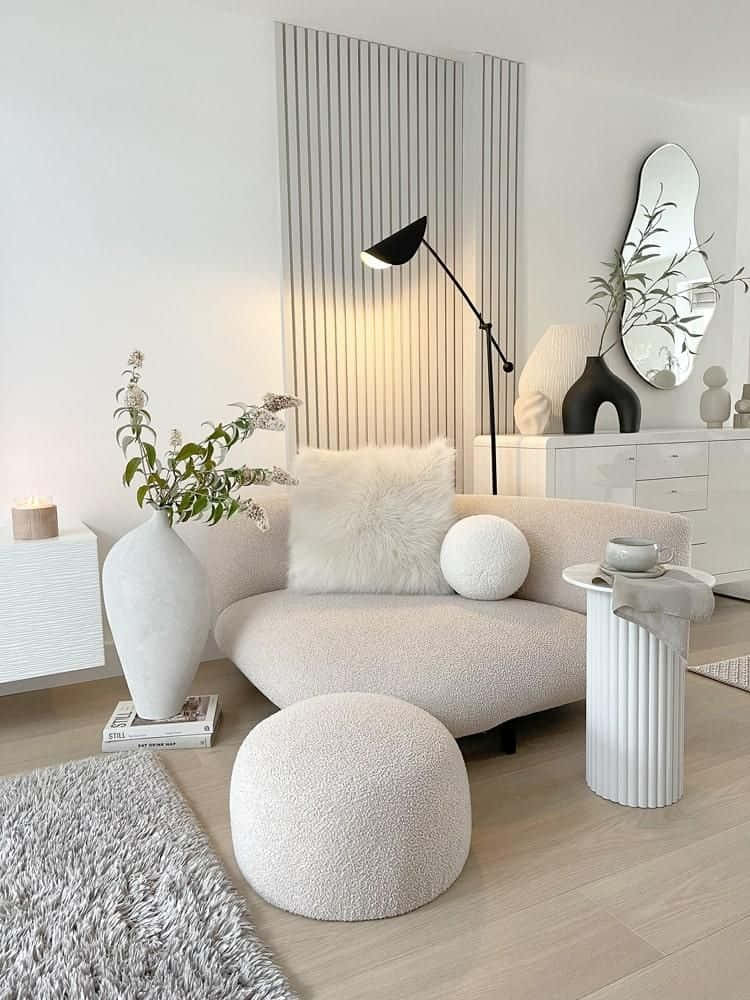 Minimalist Design 桌布 壁紙 — 一張簡約米色沙發配以柔軟抱枕，置於明亮白色現代客廳中，配有時尚家具和柔和自然光。