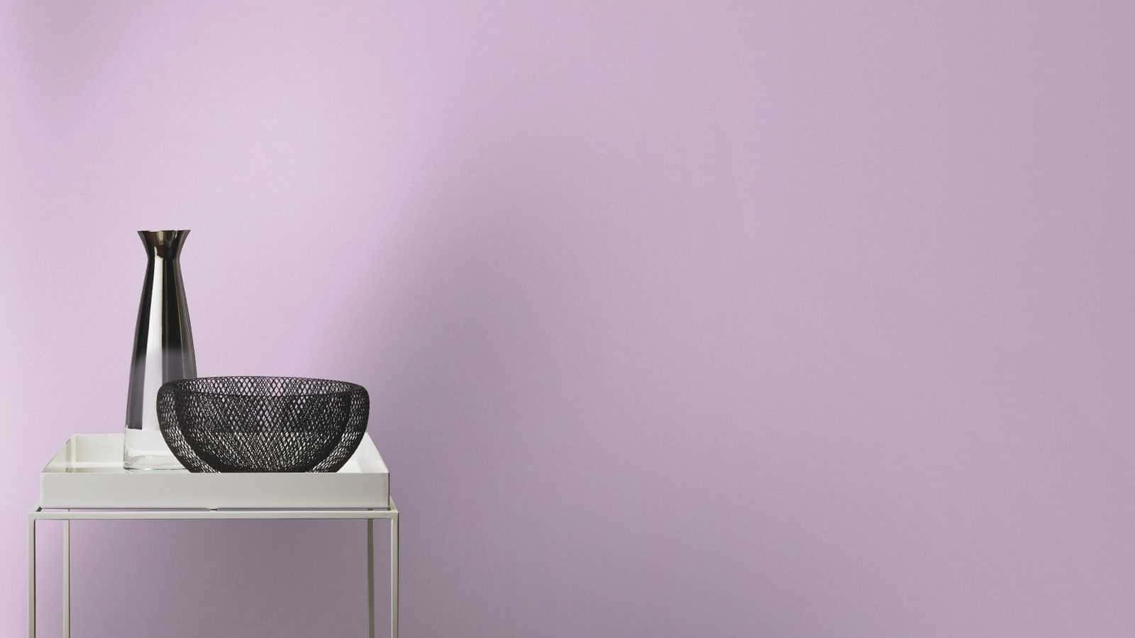 Lilac Color 桌布 壁紙 — 一張簡約風格的白色玄關桌上，擺放著一個時尚的金屬花瓶和一個黑色網紋碗，背景是柔和的薰衣草色牆壁。