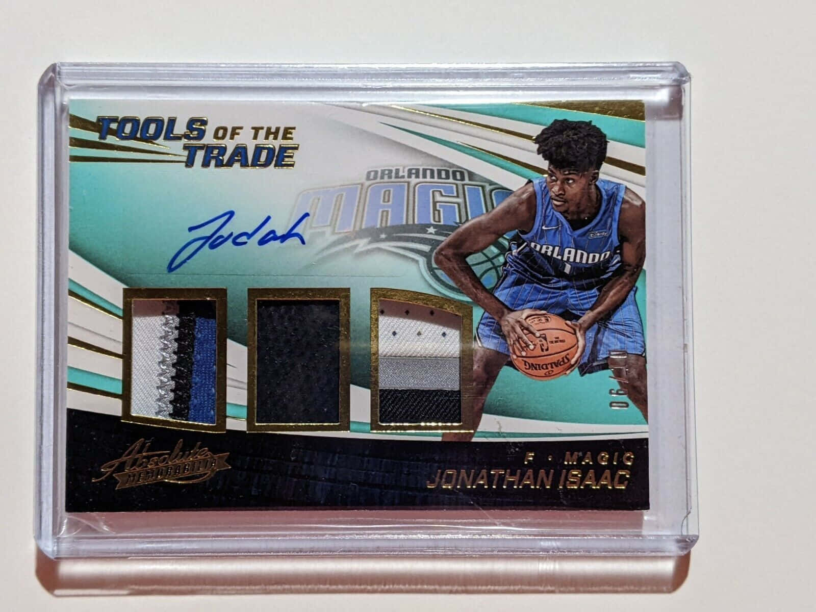 NBA 桌布 壁紙 — 一張籃球交易卡，展示穿著奧蘭多魔術隊球衣的Jonathan Isaac，手持一個帶有三塊球衣布料樣本和他的簽名的籃球。