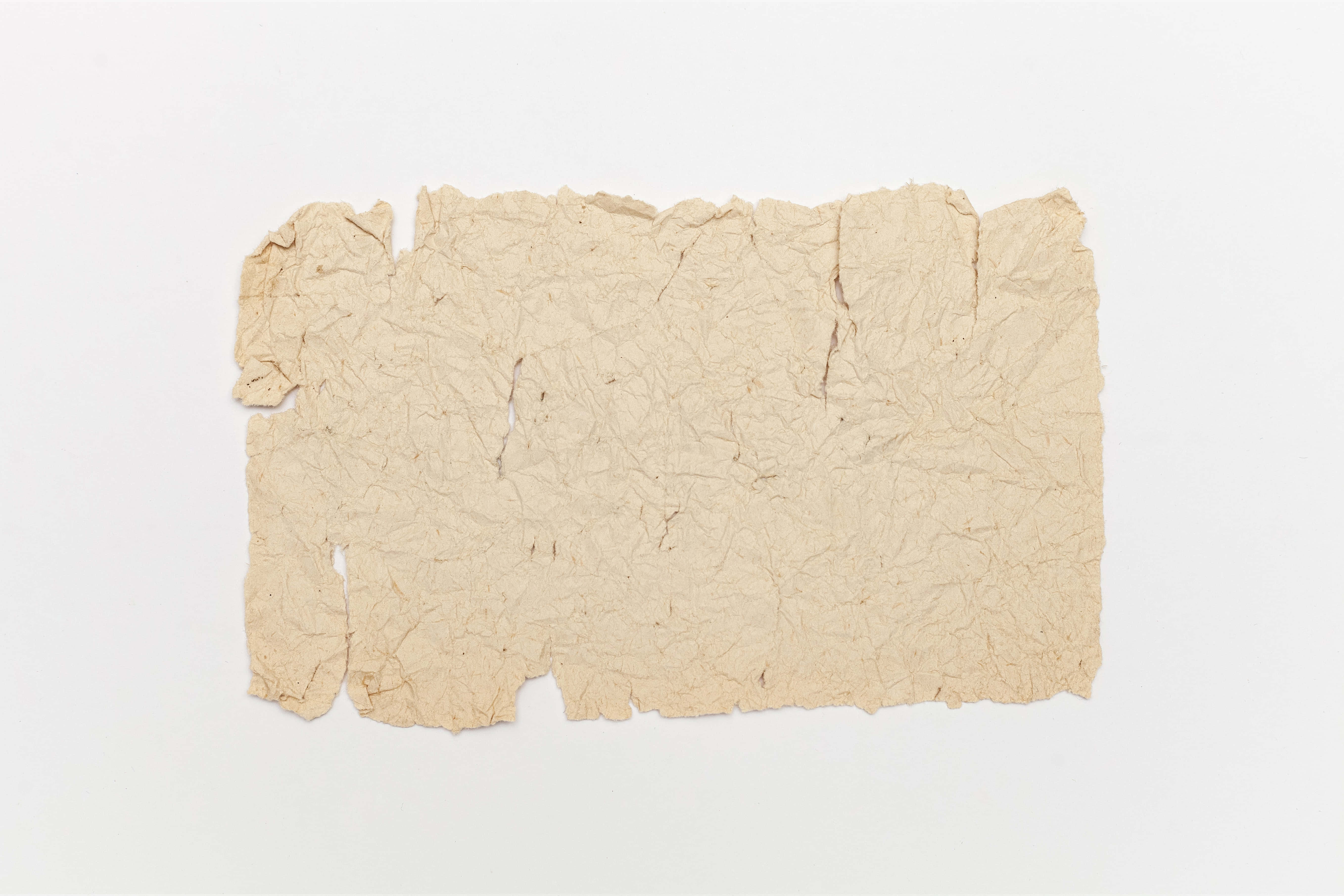 Old Paper 桌布 壁紙 — 一張米色手工紙，邊緣粗糙撕裂，皺巴巴地放在純白色背景中央。