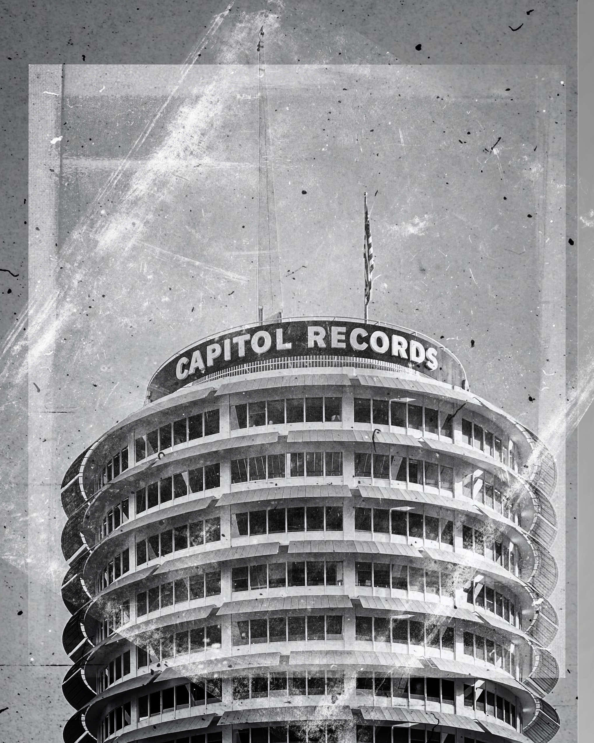 黑白 桌布 壁紙 — 一張經典的 Capitol Records 大樓黑白復古照片，帶有可見的刮痕和灰塵。