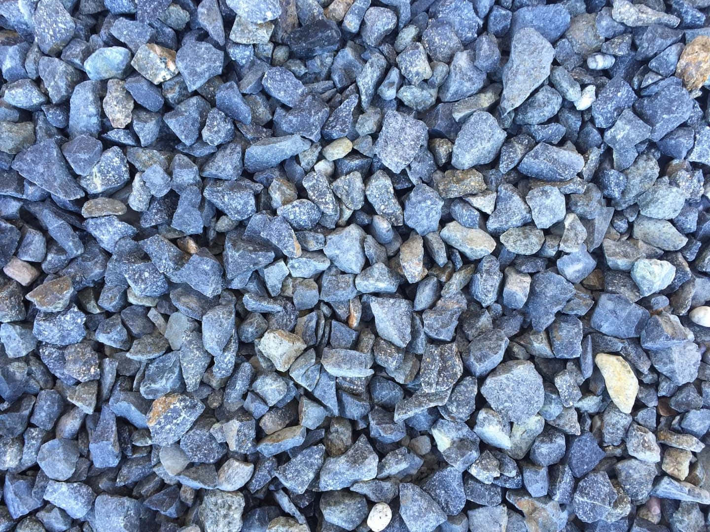 Slate Blue 桌布 壁紙 — 一張緊密排列的灰色礫石特寫照片，帶有微妙的土色調和粗糙質感。