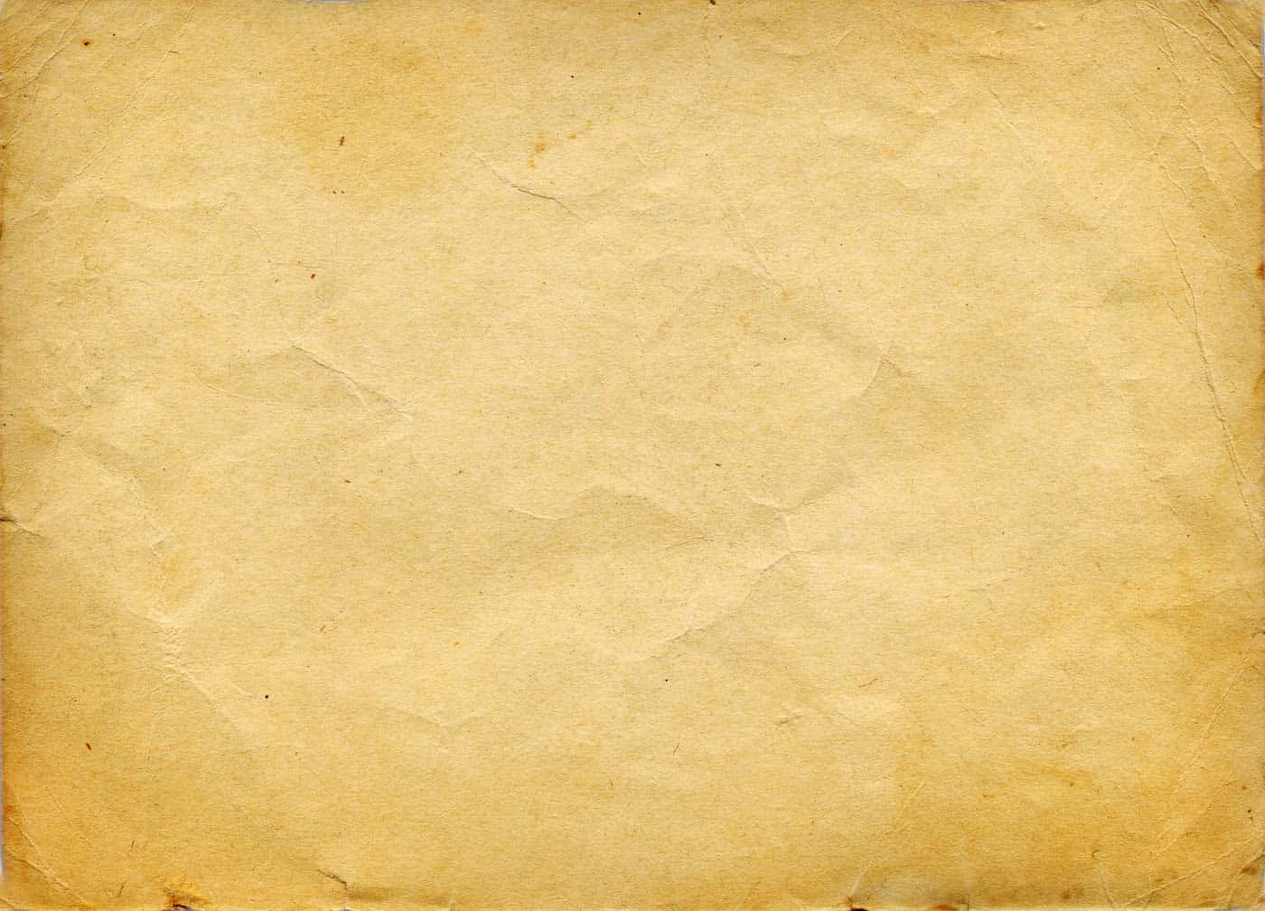 Vintage Paper 桌布 壁紙 — 一張老舊黃色羊皮紙的特寫，帶有可見的摺痕和細微污漬。