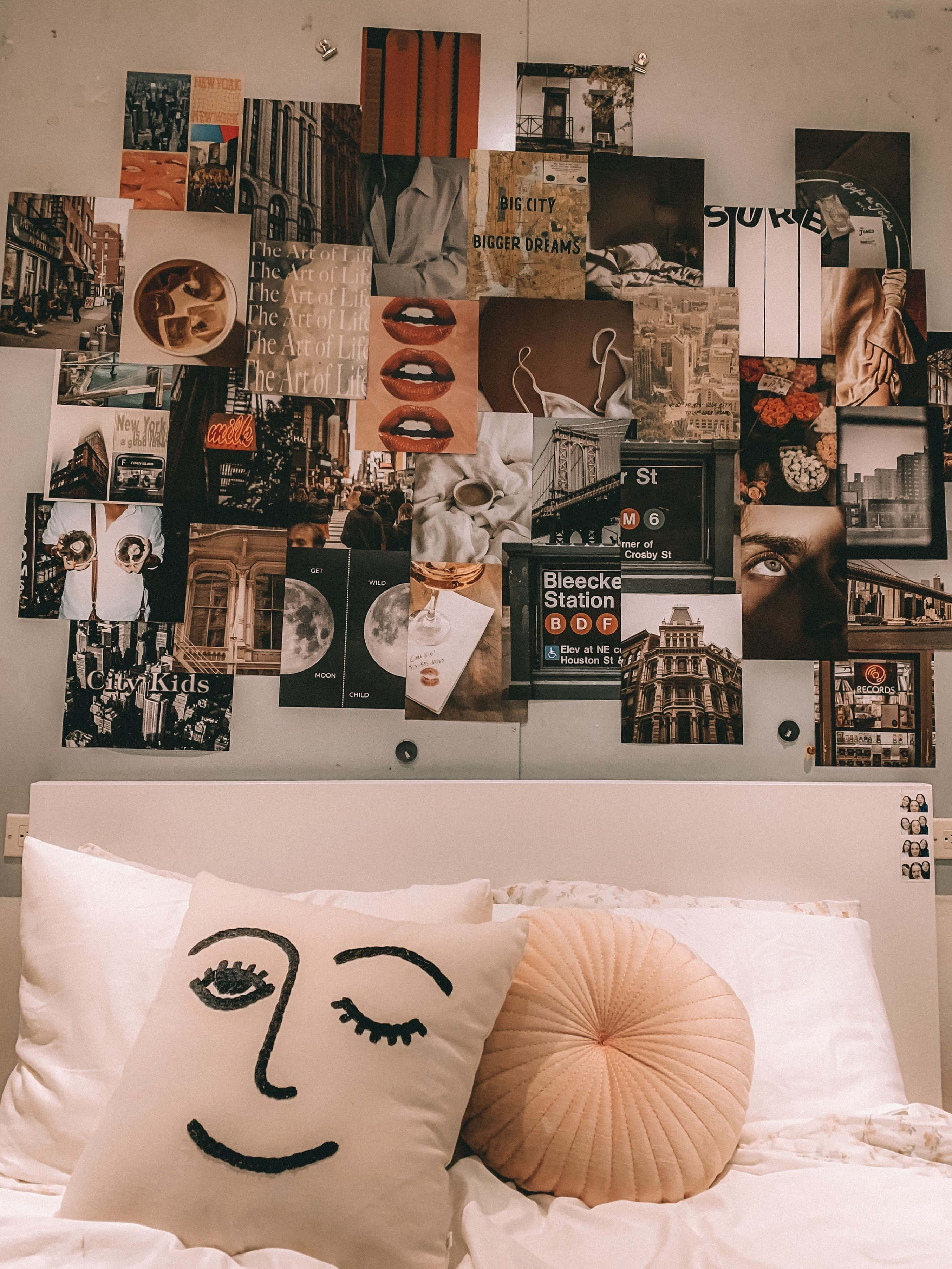 Aesthetic Room 桌布 壁紙 — 一張舒適的床，配有笑臉枕頭和一個蜜桃色圓形枕頭，牆上貼滿了不拘一格的都市和藝術海報。