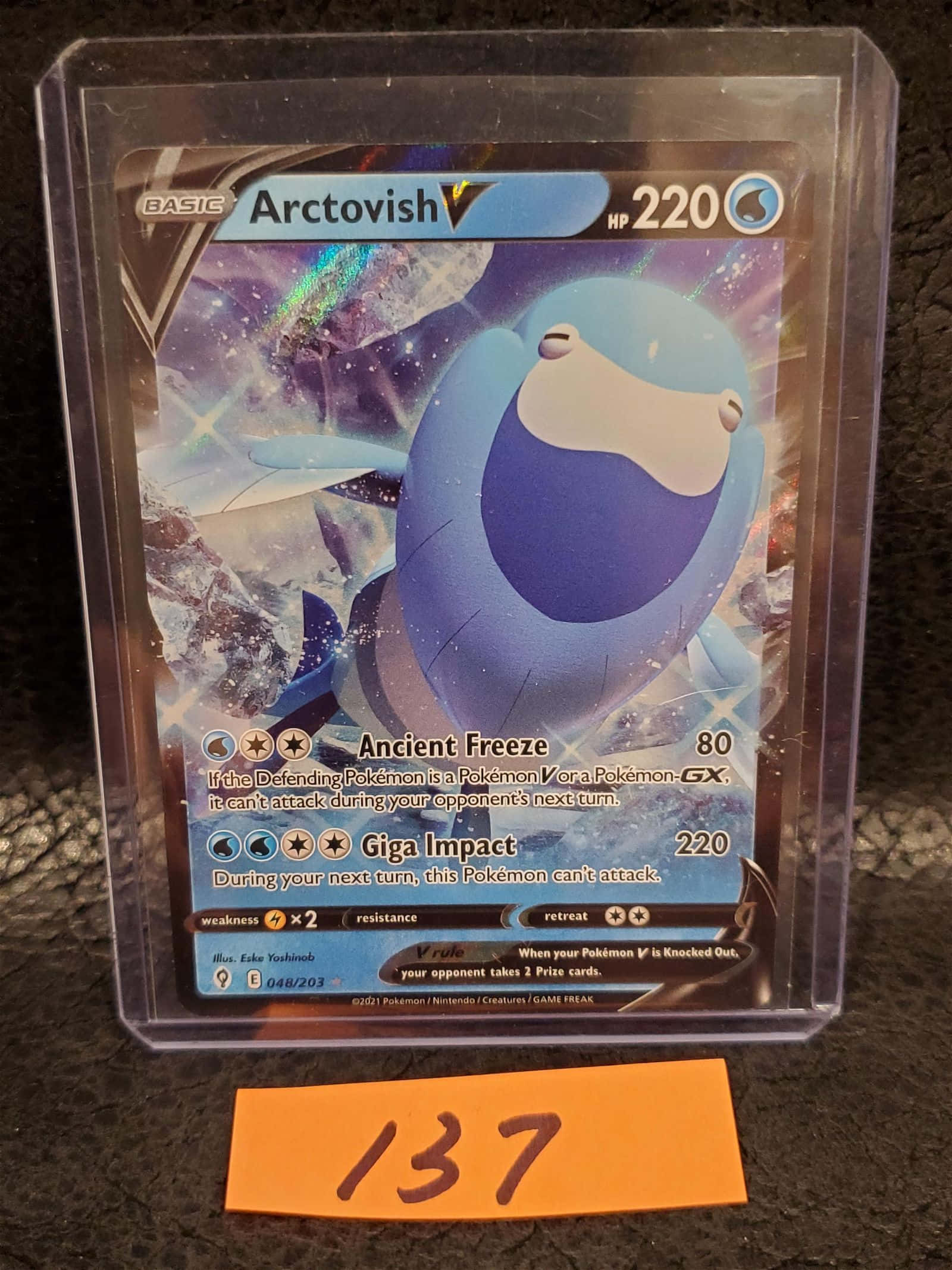 寶可夢 桌布 壁紙 — 一張藍色Arctovish V Pokémon卡放在透明保護套中，置於深色表面上，附有橙色標籤寫著137。