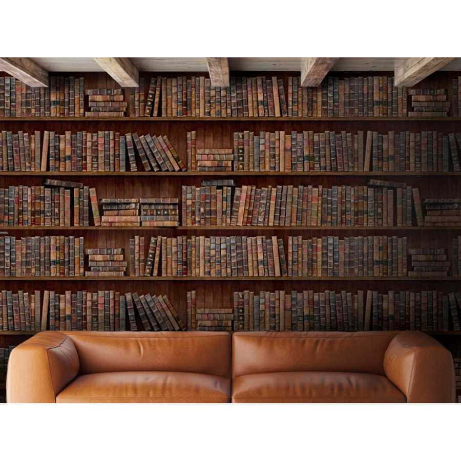 Shelves 桌布 壁紙 — 一張豐富的棕色皮革沙發放在高聳的木書架前，書架上塞滿了復古書籍，上方有裸露的橫樑。