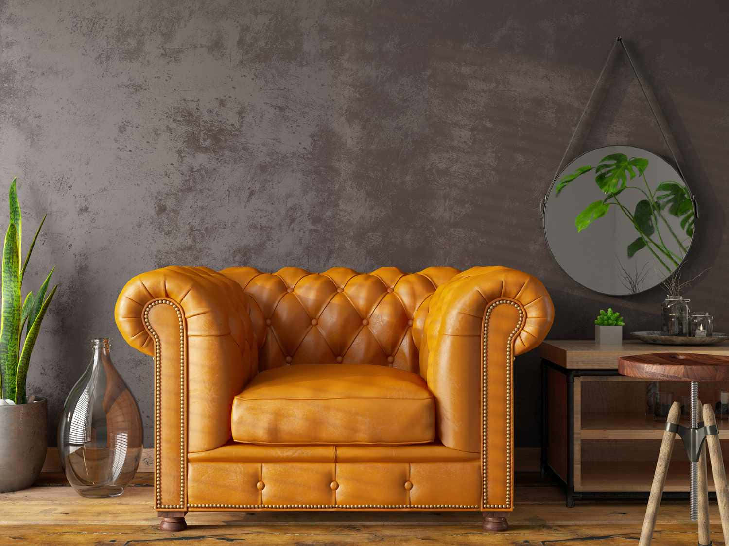 chair 桌布 壁紙 — 一張豐富的琥珀色簇絨皮革 Chesterfield 沙發位於質樸的工業風房間，配有紋理灰色牆壁和木地板。