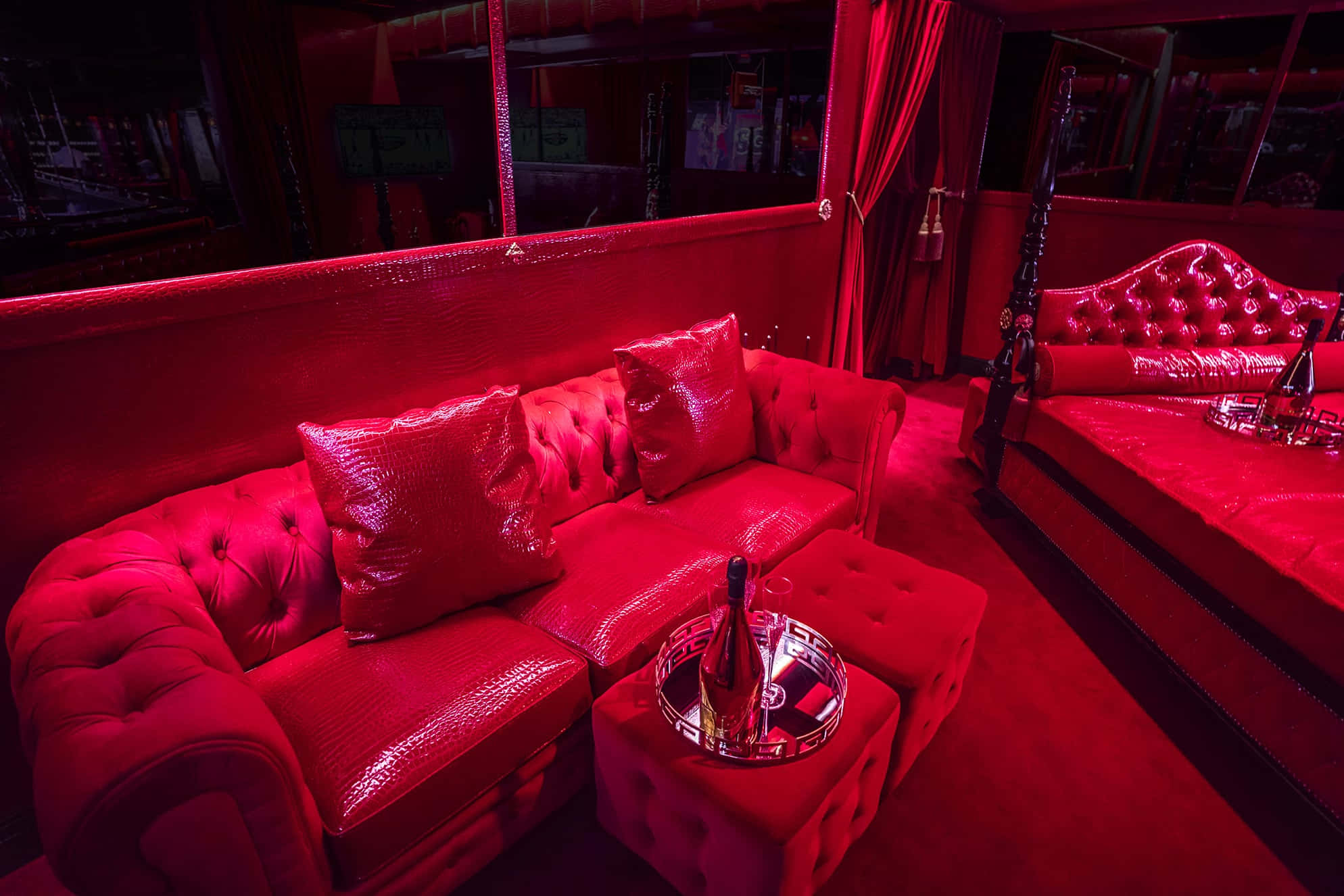 Red Room 桌布 壁紙 — 一張豪華的紅色簇絨沙發和配套的床在夜總會休息室的環境紅光下閃耀。