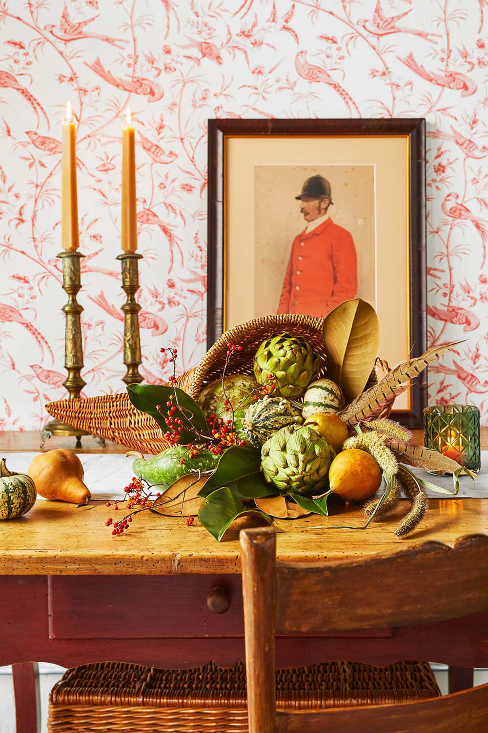 Fall Cornucopia 桌布 壁紙 — 一張質樸的木桌上展示著充滿活力的秋日靜物，有朝鮮薊、梨子和漿果，背景是紅色鳥圖案壁紙。