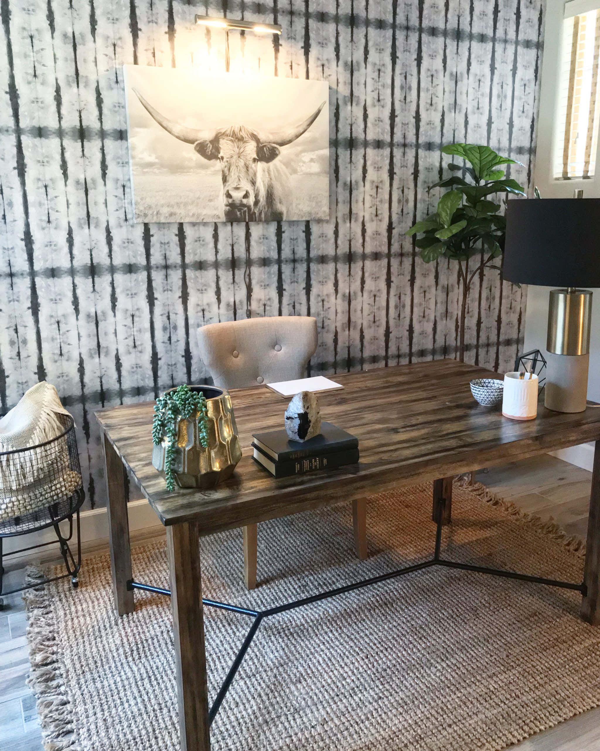 Interior Design 桌布 壁紙 — 一張質樸的木桌放置在舒適的家庭辦公室中，配有紮染壁紙和上方的大型公牛藝術品。