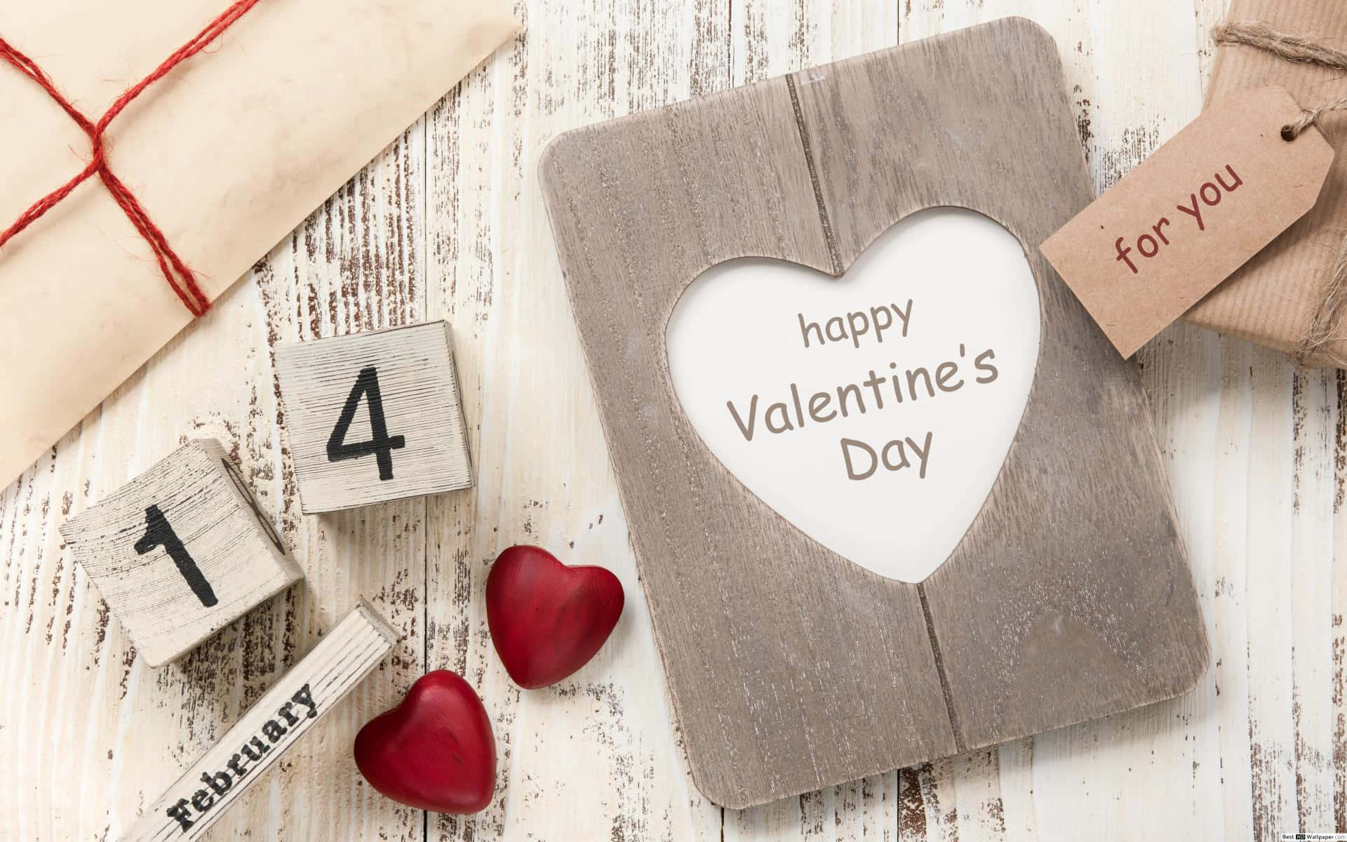 桌布 壁紙 — 一張鄉村風格的情人節卡片，有心形鏤空和「happy Valentine's Day」文字，旁邊有紅色心形木塊顯示2月14日，以及一個寫著「for you」的包裝禮物標籤。