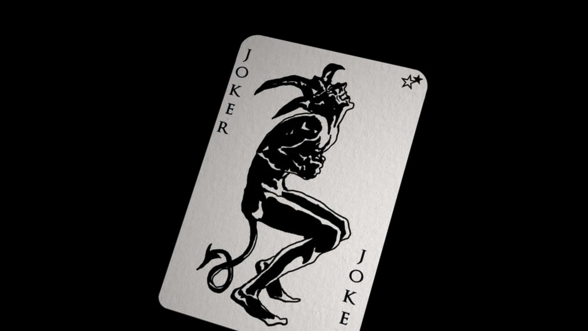 Card Games 桌布 壁紙 — 一張金屬質感的鬼牌撲克牌，上面有黑色魔鬼插圖，傾斜放置在純黑背景上。
