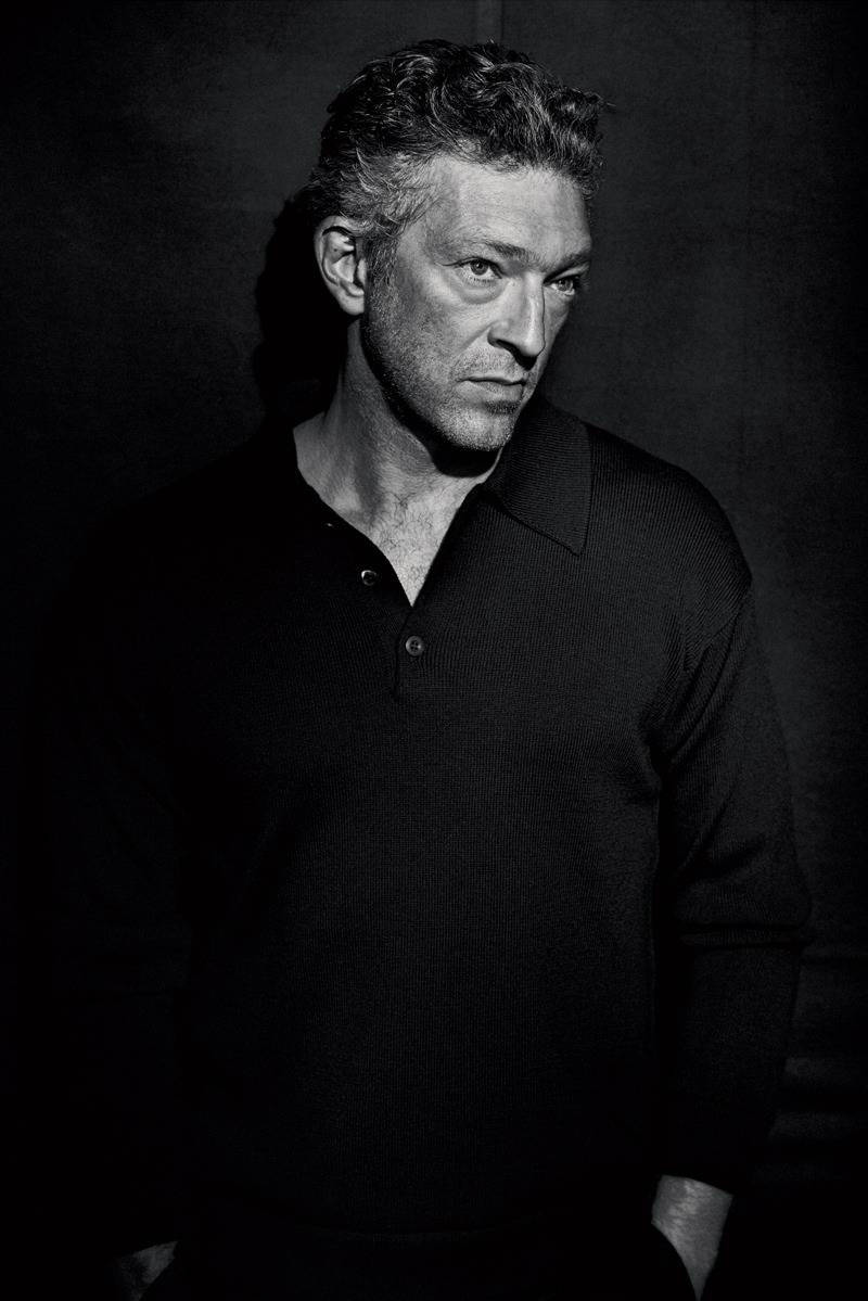 actor 桌布 壁紙 — 一張陰鬱的黑白肖像照，捕捉了一位頭髮有紋理、眼神銳利的男士，背景為深色。