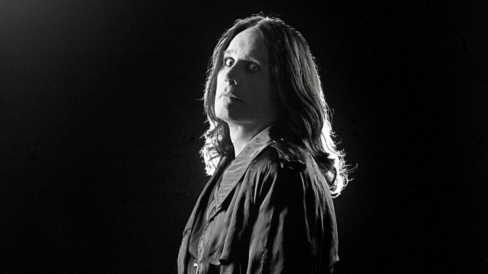 Ozzy Osbourne 桌布 壁紙 — 一張陰鬱的黑白肖像照，長髮男子在黑暗背景下從側面打光。