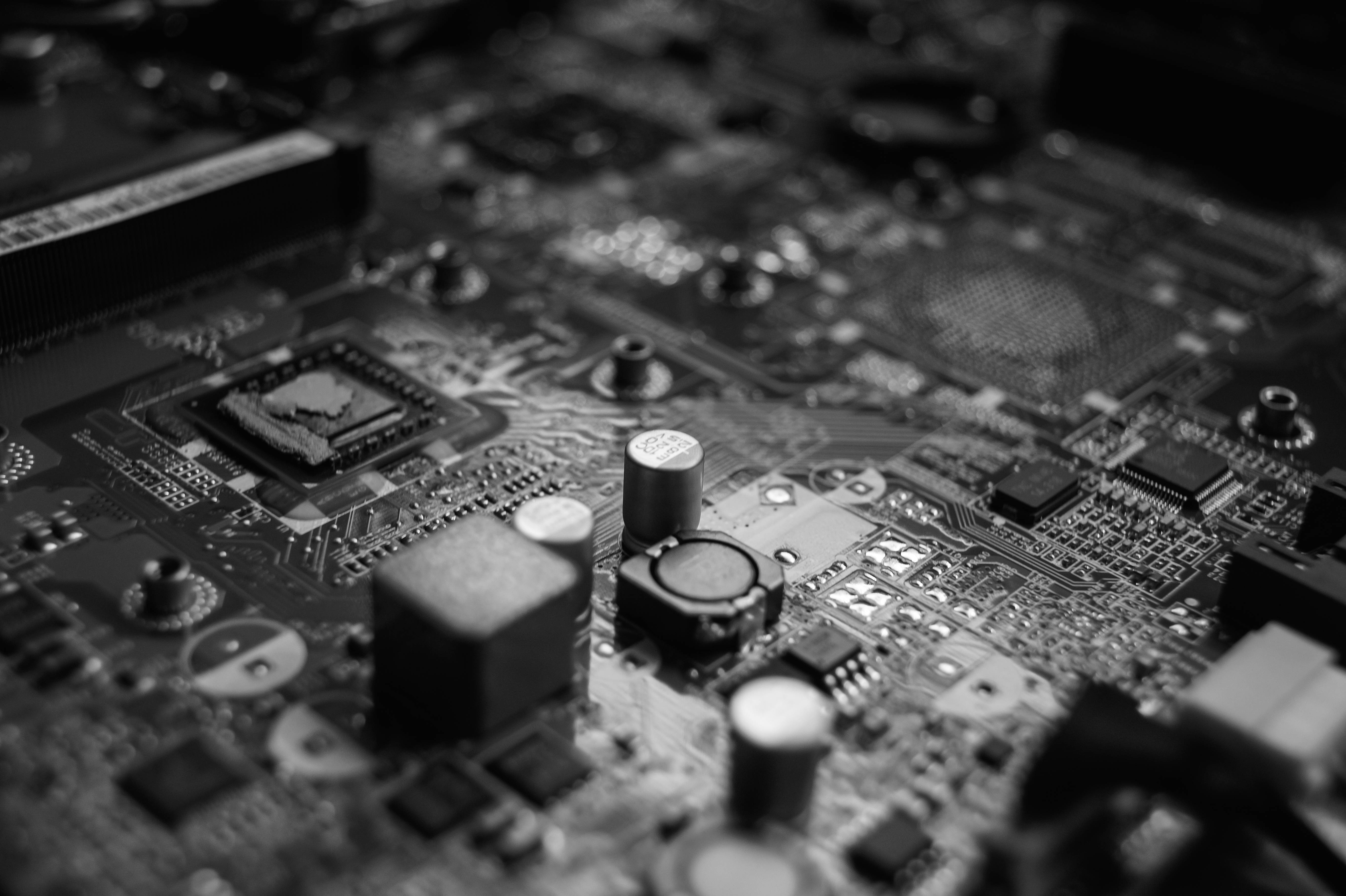 Motherboard 桌布 壁紙 — 一張電腦主機板的單色微距照片，電路和電子元件細節清晰銳利。