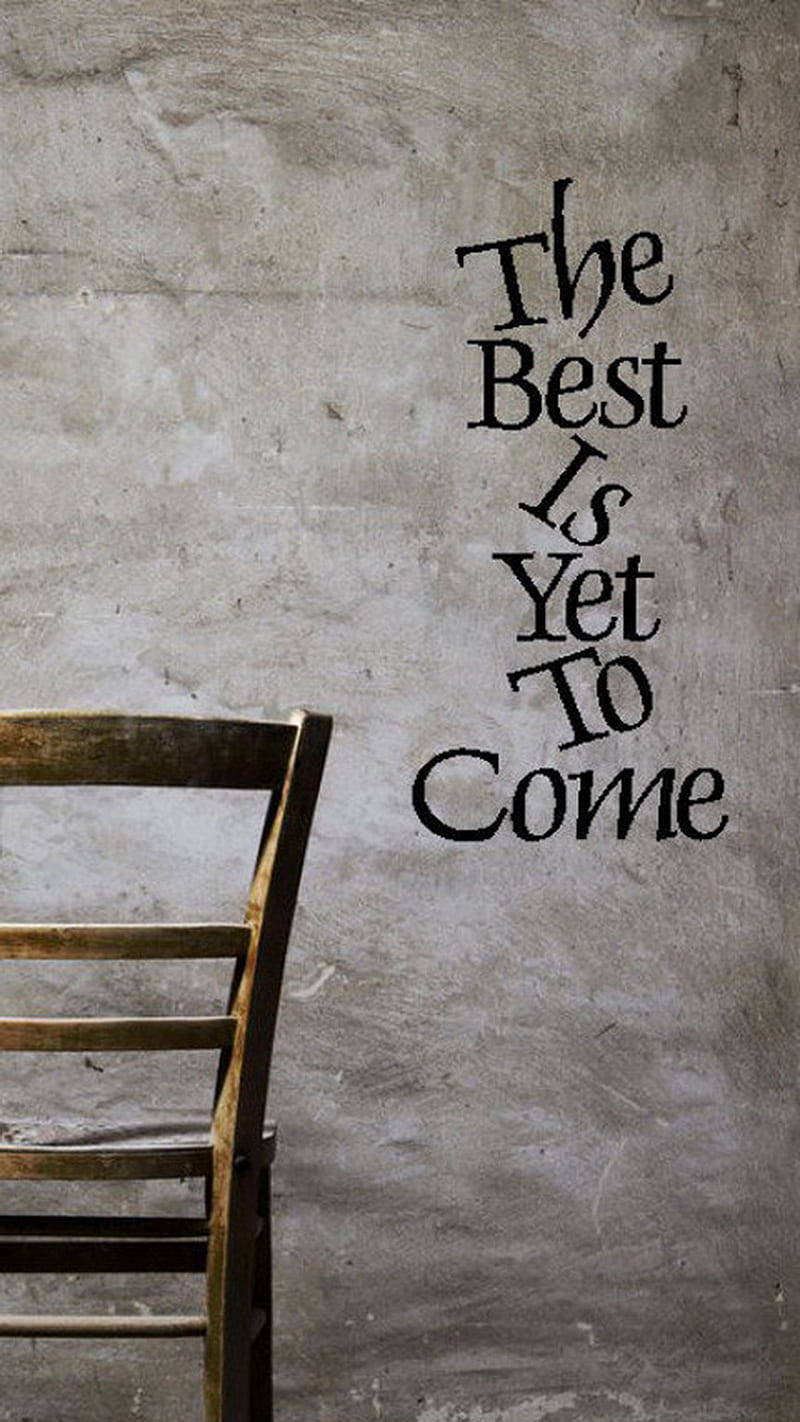 一張木椅旁邊的牆上寫著 The Best Is Yet To Come。 — 勵志手機桌布 壁紙