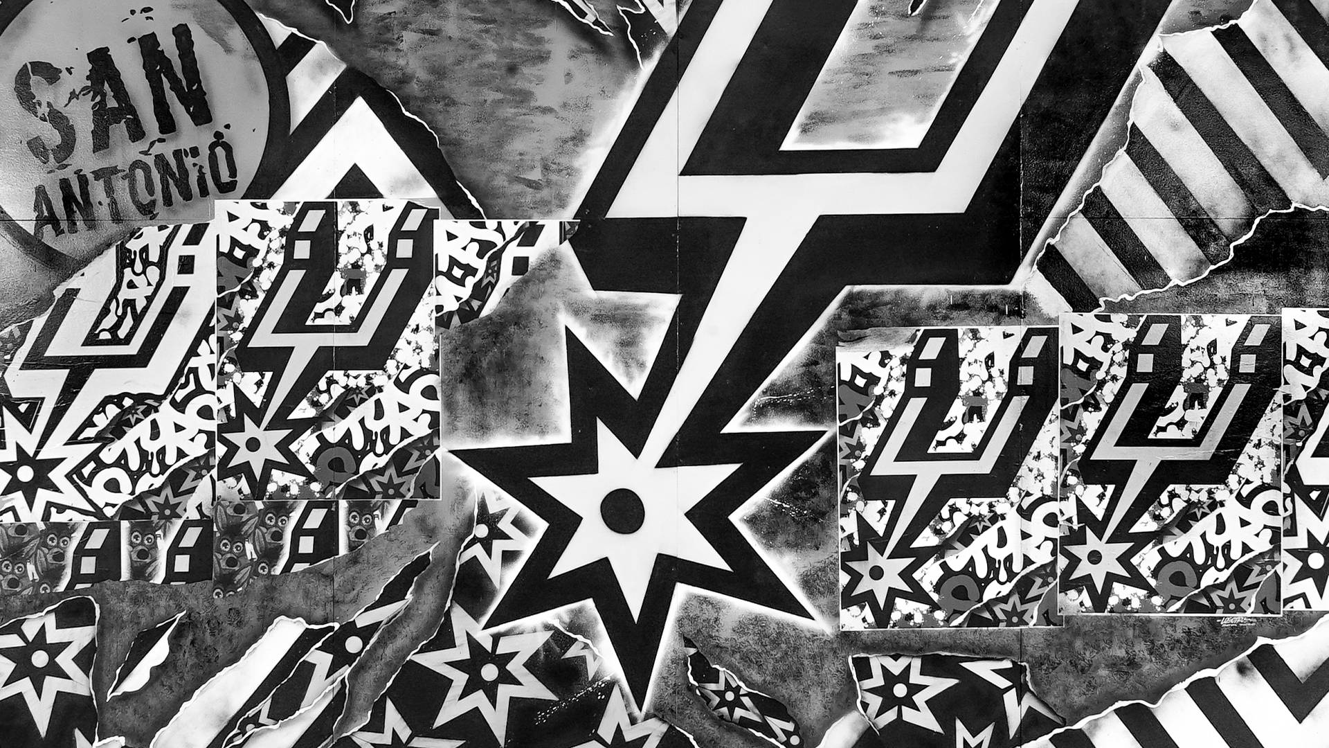 Spurs 桌布 壁紙 — 一張高對比度的黑白拼貼畫，以星星和閃電為特色，呈現撕裂的聖安東尼奧馬刺籃球隊圖案。