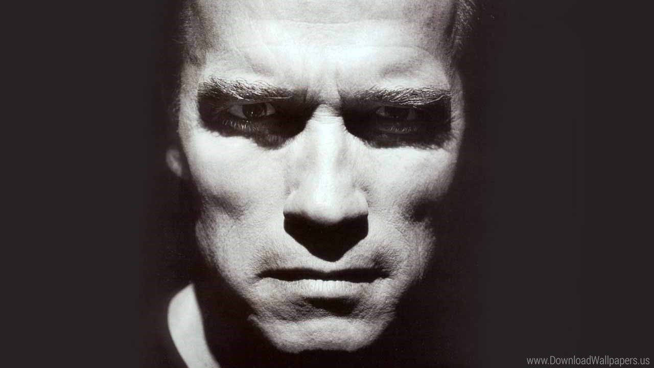 Arnold 桌布 壁紙 — 一張高對比度的黑白特寫，捕捉一個男人充滿強烈情感的面孔，帶有戲劇性的陰影和銳利的眼神。