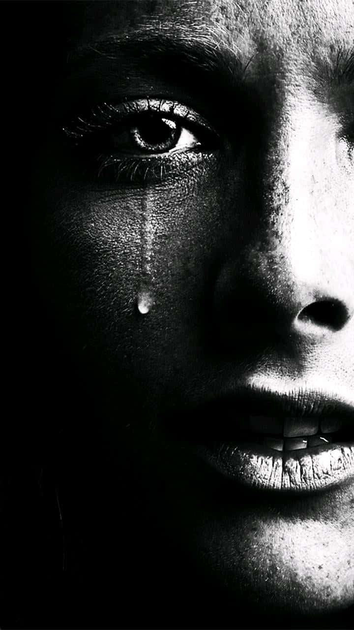 Depressed 桌布 壁紙 — 一張高對比度的黑白特寫，捕捉女性臉頰上的一滴淚水在戲劇性燈光下滾落。