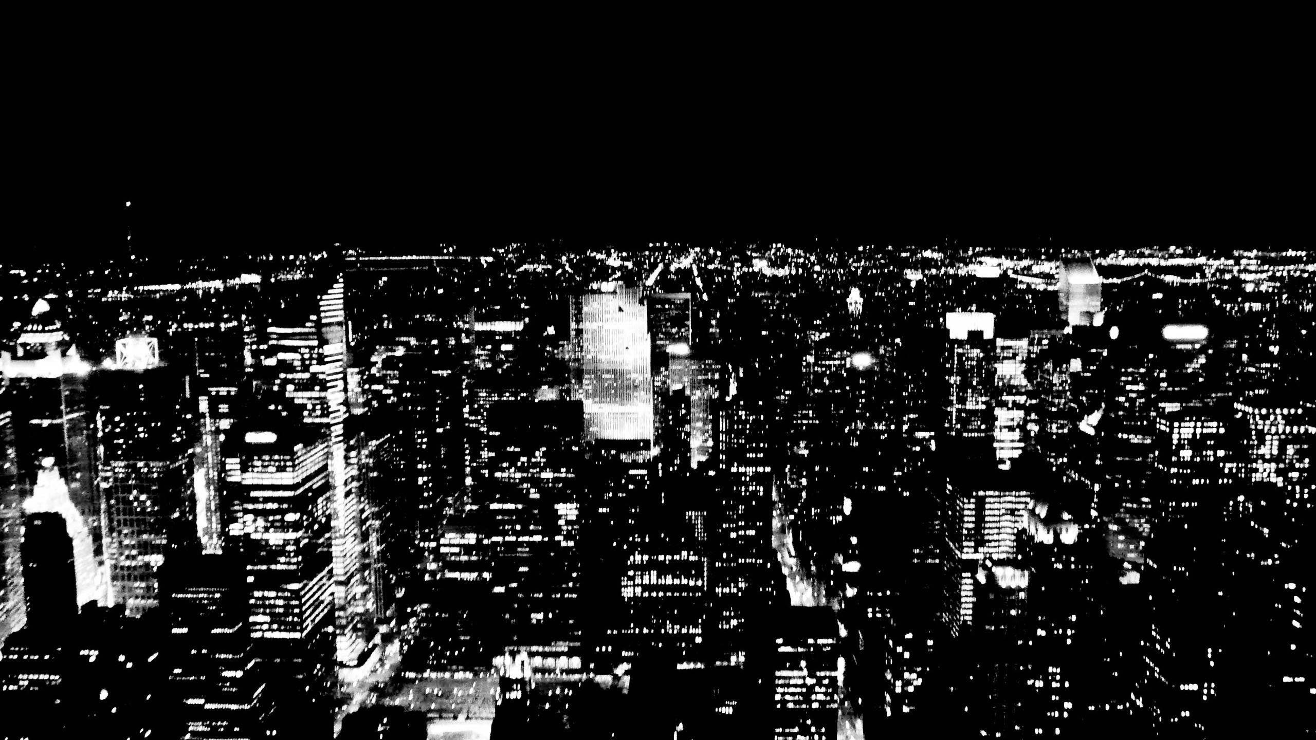 New York 桌布 壁紙 — 一張高對比度的黑白航拍照片，展現了夜晚廣闊的城市景觀，無數窗戶閃爍著光芒。